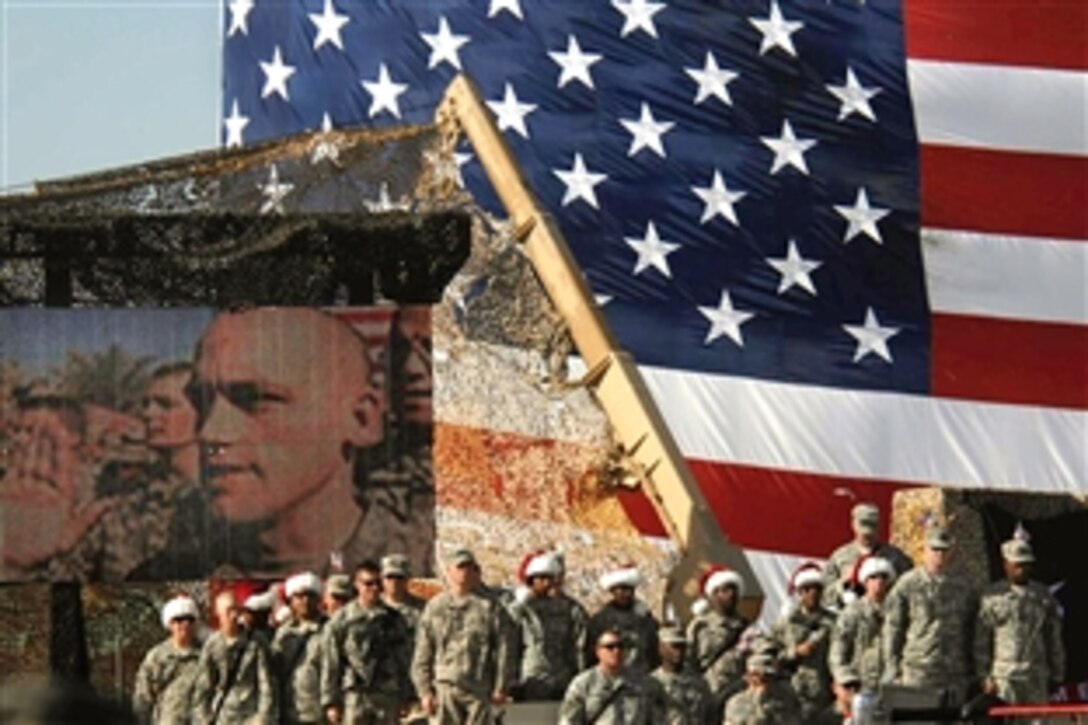 U.S. Army soldiers deployed in Baghdad, Iraq, recite the oath of enlistment, near the ring, as they re-enlist during the beginning of the World Wrestling Entertainment tour at Camp Victory, Baghdad, Iraq, Dec. 5, 2008.