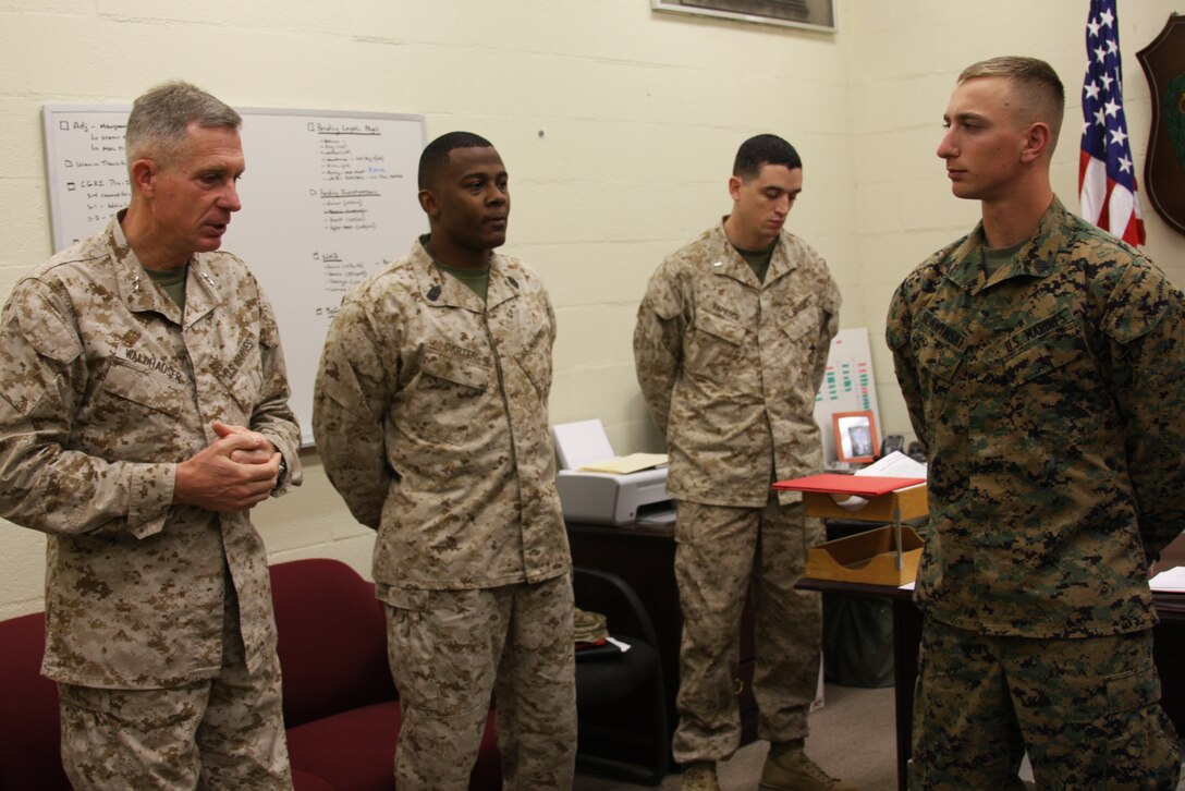 Sgt. John Slawinski, a section leader with assault weapons platoon, Company I, 3rd Battalion, 4th Marine Regiment, stands prepared to receive a Navy Achievement Medal from Maj. Gen. Thomas Waldhauser, commanding general of 1st Marine Division, and Sgt. Maj. Randall Carter, 1st Marine Division sergeant major, at the 3/4 headquarters building Dec 9.