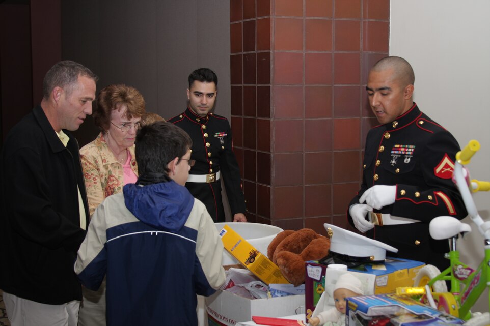 Cpl. Cesar Alvarado Miranda and Lance Cpl. John Torres Perez, Combat Center Toys for Tots Foundation representatives, receive donations from Palms Springs, Calif., residents at the Palm Springs Convention Center Dec. 9. Toys for Tots teamed up with the Food In Need of Distribution food bank and the Combat Center Band to help make the holidays brighter for needy families.
