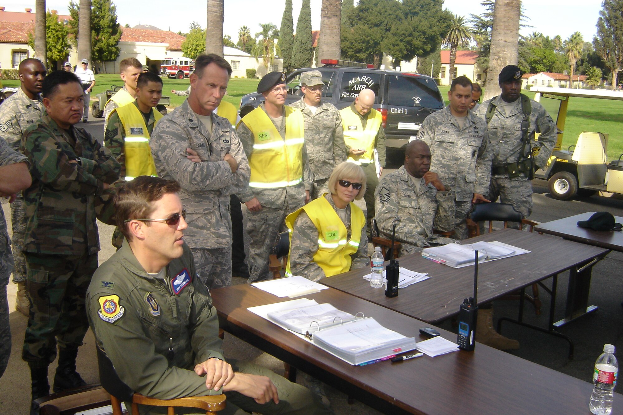 Col. Jeffrey Barnson, 452 AMW vice commander, confers with commanders at the Installation Control Center. (U.S. Air Force photo by Will Alexander)