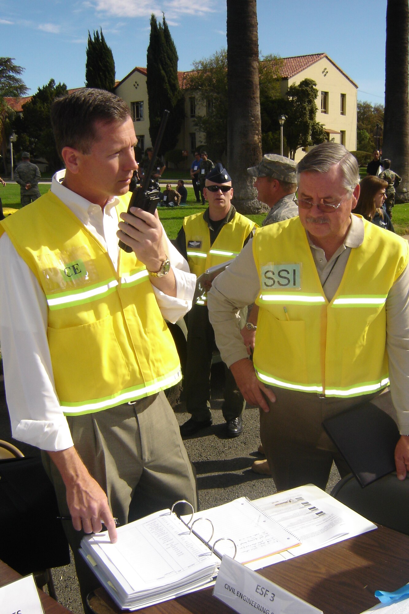 Richard Eunice, Base CE, communicates via radio at the EOC as James Rossi, SSI, assists. (U.S. Air Force photo by Will Alexander)