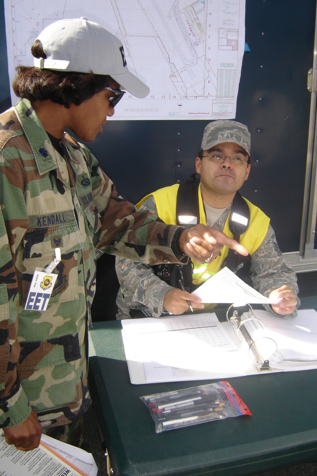 Lt. Col. Scipiaruth Kendall, Exercise Evaluator Team chief, speaks with SrA Joel Aspeytia, 452 CES, as he collects damage reports from various units. (U.S. Air Force photo by Will Alexander)