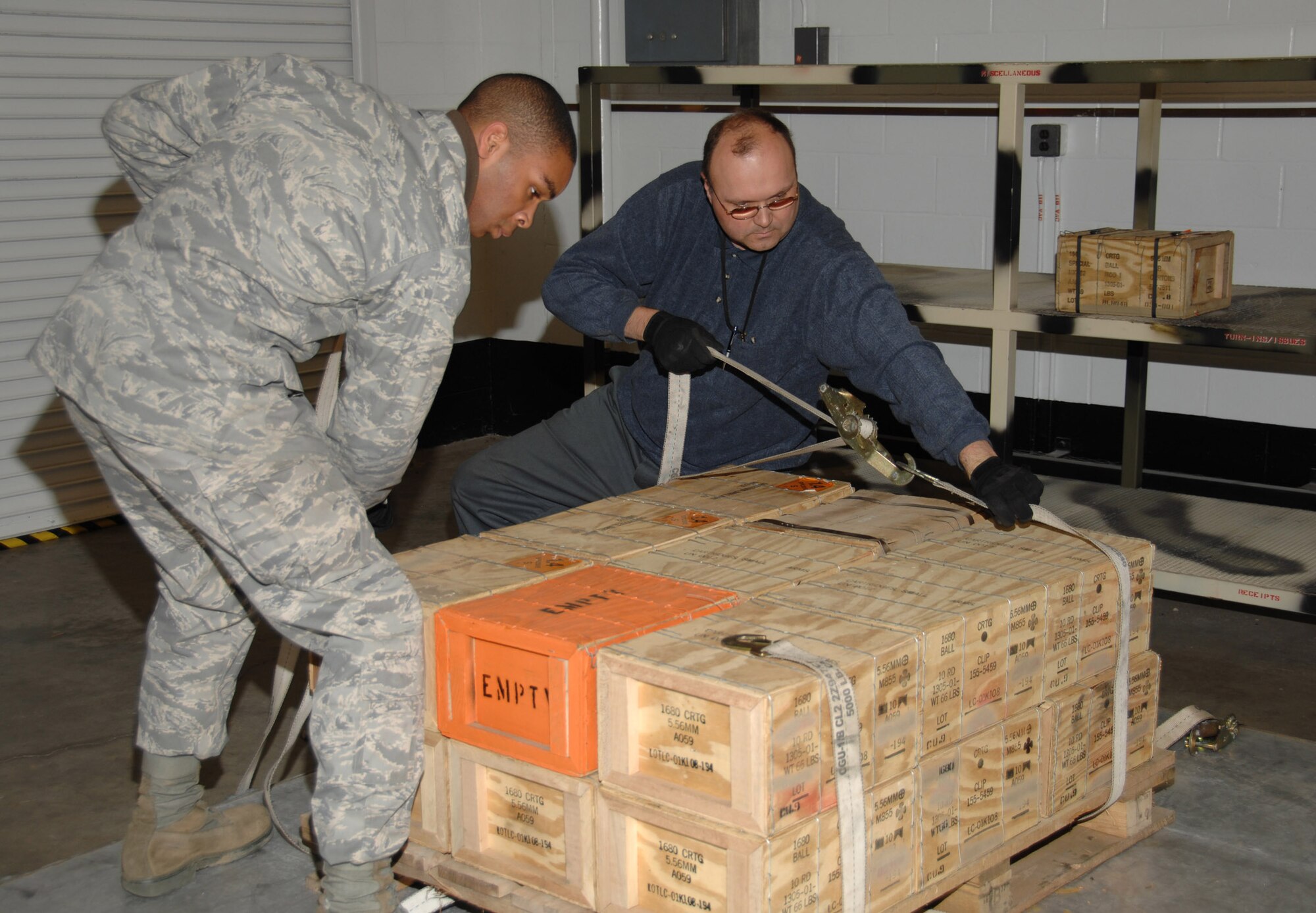 Munitions specialist Airman 1st Class Kyle Johnson and Bill Crenshaw, chief of the 88th Operations Support Squadron Munitions Flight, prepare pallets of small arms ammo for shipment Dec. 5 inside the Weapons Storage Area at Wright-Patterson Air Force Base. Base Airmen participated in a crisis response deployment exercise which simulated the deployment of more than 200 personnel and nearly 60 tons of cargo to an air base in Asia.  The exercise is part of base preparations for the 2009 Operational Readiness Inspection.  (U.S. Air Force photo/Ben Strasser) 