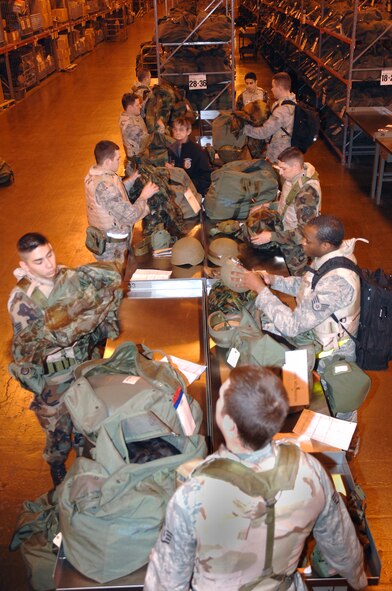 A group of 88th Communications Squadron Airmen inventory the contents of their deployment gear inside the Wright-Patterson Air Force Base mobility bag warehouse Dec. 8.  More than 200 base Airmen participated in the exercise which simulated a mass deployment to an air base in Asia.  The exercise is part of base preparations for the 2009 Operational Readiness Inspection  (U.S. Air Force photo/Al Bright) 