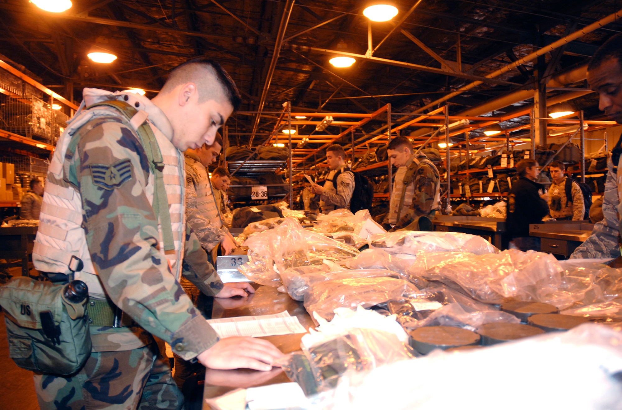 Staff Sgt. Jesus Borunda, a voice networks technician with the 88th Communications Squadron, inventories his "C-Bag" containing chemical and biological protective gear inside the Wright-Patterson Air Force Base mobility bag warehouse.  Borunda was among more than 200 base Airmen who participated in an exercise Dec. 8 which simulated a mass deployment to an air base in Asia.  (U.S. Air Force photo/Al Bright) 