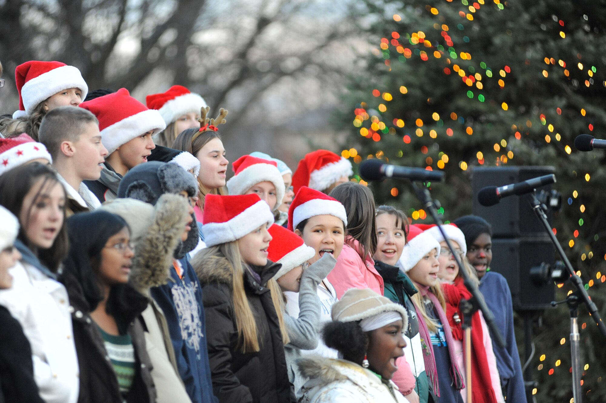 A choir from Northern Burlington High School sings classic Christmas carols during the annual tree lighting ceremony at Chapel One Dec. 5 at McGuire AFB, N.J. The event drew a large crowd and featured a special visitor who arrived from the North Pole in a Blackhawk helicopter.(U.S. Air Force photo/Carlos Cintron)