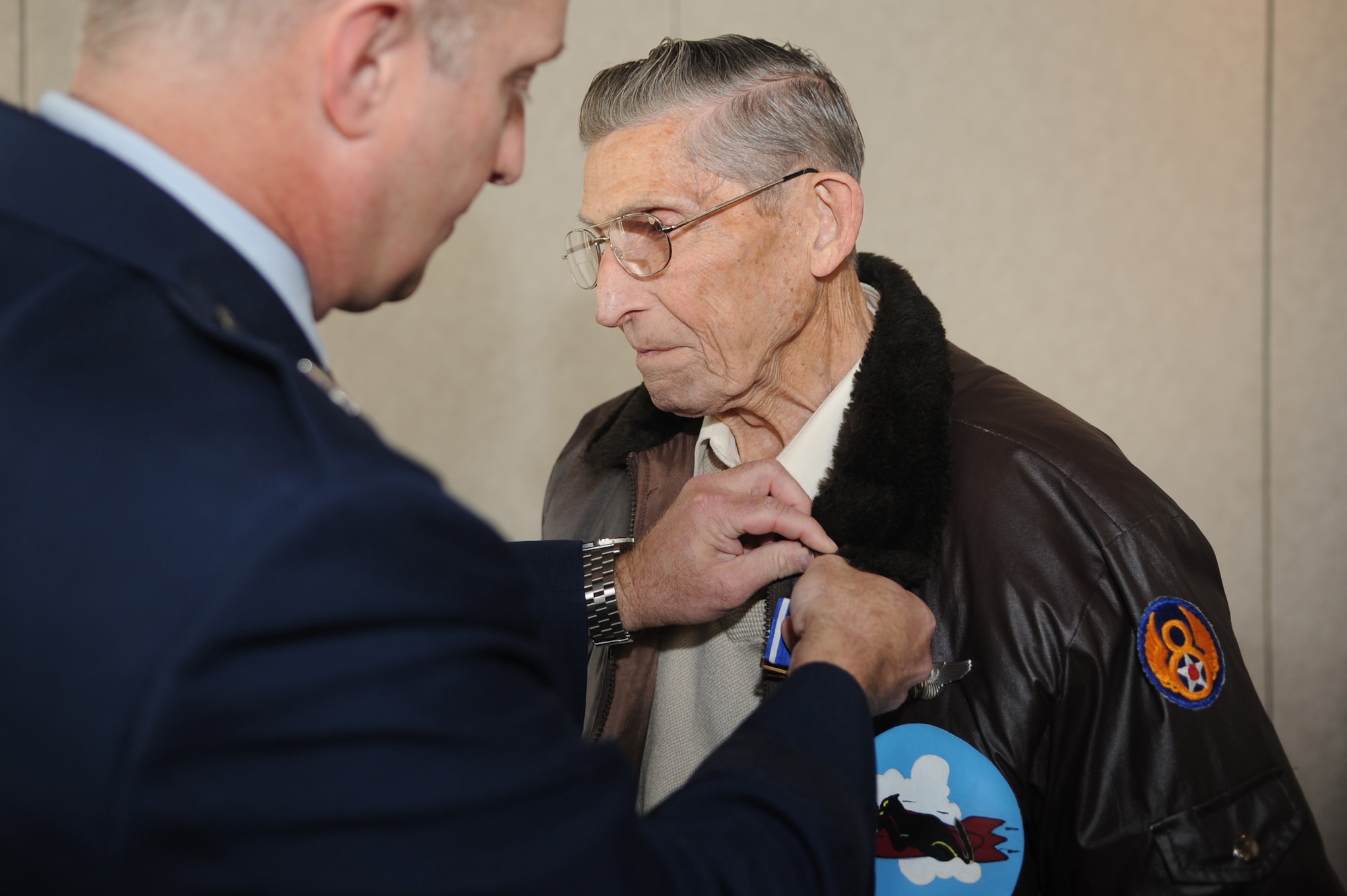 WHITEMAN AIR FORCE BASE, Mo. - Brig. Gen. Garrett Harencak, 509th Bomb Wing commander, pins the Distinguished Flying Cross on Edward Ireland's Flight Jacket Dec. 6 during a ceremony at the Royal Oaks Golf Course here. Mr. Ireland earned the medal more than 60 years ago for his actions as a top turret gunner on B-17 Flying Fortress bombers during World War II. Due to missions during the war, Mr. Ireland was never formally presented his medal. (U.S. Air Force photo/Senior Airman Jessica Snow)