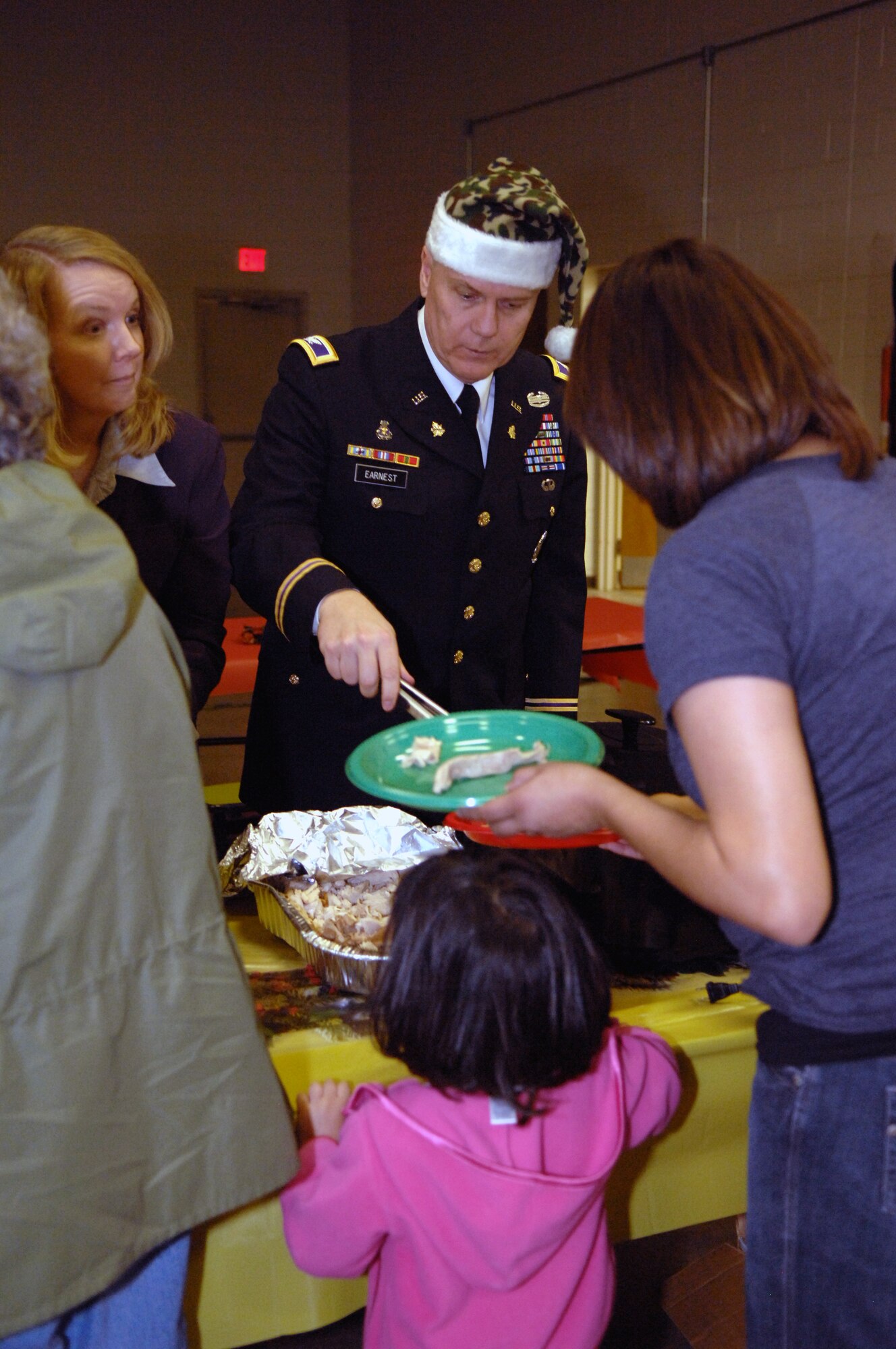 ABILENE, Texas -- Col. Frank Earnest and his wife, Lena, serve more than 100 Soldiers and their families at their annual holiday party Dec. 6. Colonel Earnest and his wife flew down to Abilene for the weekend from their home in Colorado Springs, Colo., where he holds a full-time civilian position at the NORAD/NORTHCOM interagency command desk. (U.S. Air Force photo/Senior Airman Carolyn Viss)