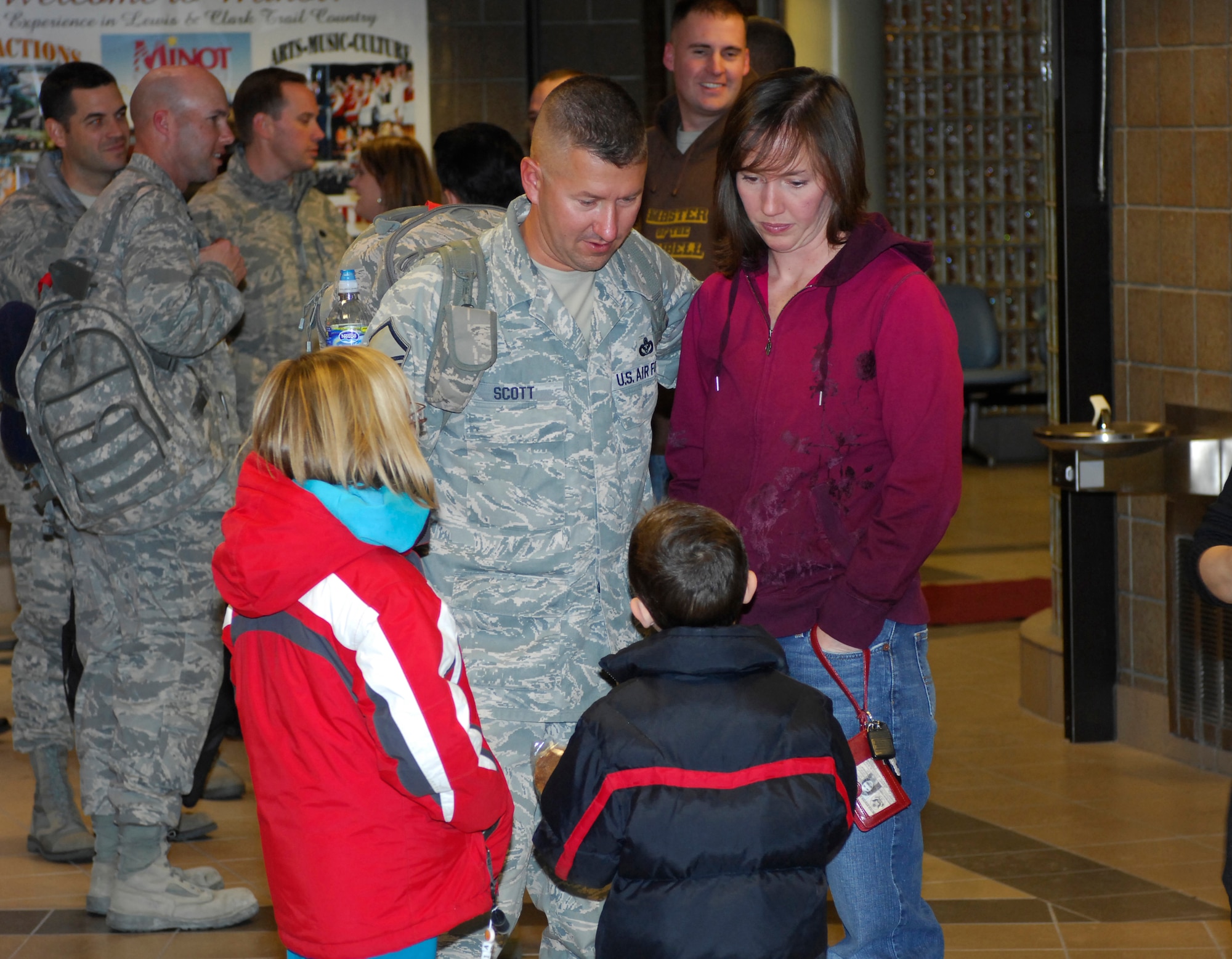 MINOT AIR FORCE BASE, N.D. -- Master Sgt. Roger Scott, Jr., 5th Civil Engineer Structures section chief, talks to his son and daughter Dec. 5 while waiting for his luggage at the Minot International Airport here upon arriving home from a 4-month deployment in support of Continuing Promise.  Continuing Promise is a joint military and civilian endeavor to bring humanitarian relief services to the people of Latin America and the Caribbean.