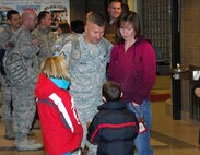 MINOT AIR FORCE BASE, N.D. -- Master Sgt. Roger Scott, Jr., 5th Civil Engineer Structures section chief, talks to his son and daughter Dec. 5 while waiting for his luggage at the Minot International Airport here upon arriving home from a 4-month deployment in support of Continuing Promise.  Continuing Promise is a joint military and civilian endeavor to bring humanitarian relief services to the people of Latin America and the Caribbean.