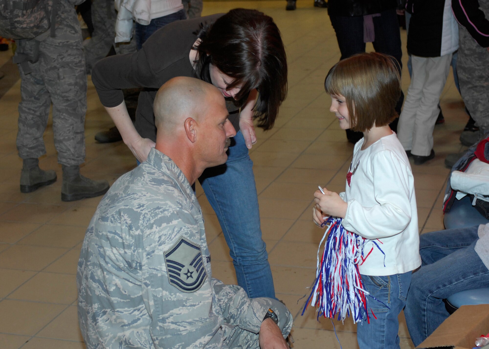 MINOT AIR FORCE BASE, N.D. -- Master Sgt. Ray Bedwell, 5th Civil Engineer Squadron base emergency engineering force liaison, talks to his daughter Dec. 5 at the Minot International Airport here upon arriving home from a 4-month deployment in support of Continuing Promise. Continuing Promise is a joint military and civilian endeavor to bring humanitarian relief services to the people of Latin America and the Caribbean.