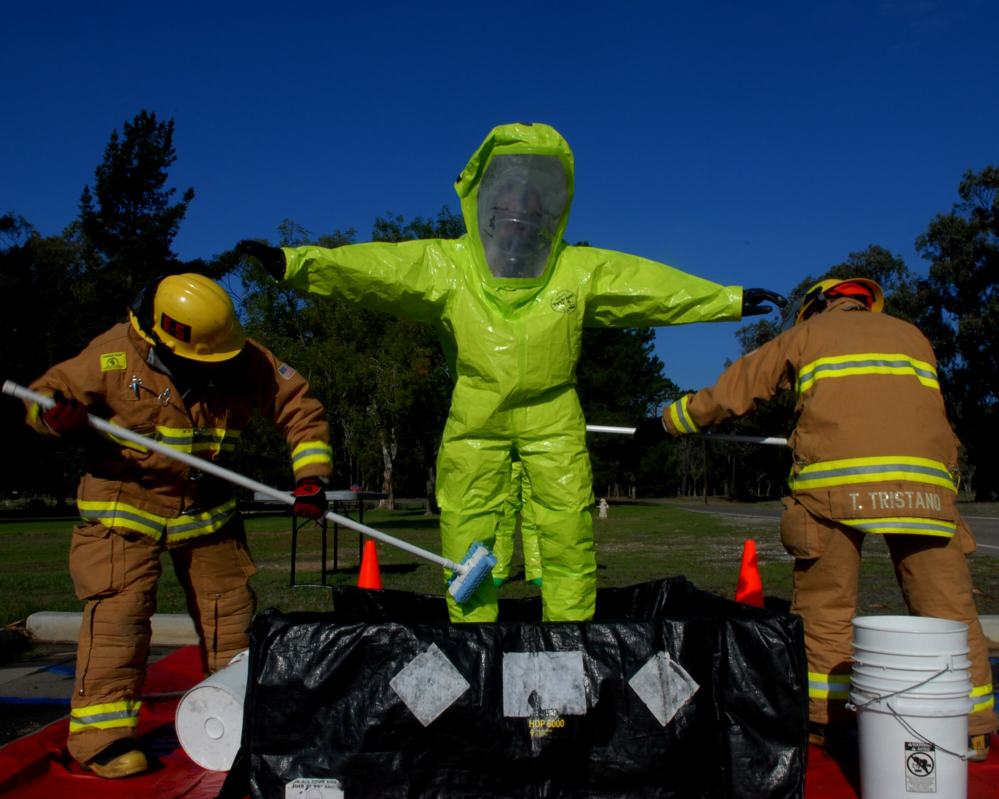 VANDENBERG AIR FORCE BASE, Calif.-- Vandenberg firefighters scrub and rinse possible contamination off of airman at the decontamination station during an exercise at Cocheo Park. (U.S. Air Force photo/Airman 1st Class Antoinette Lyons)