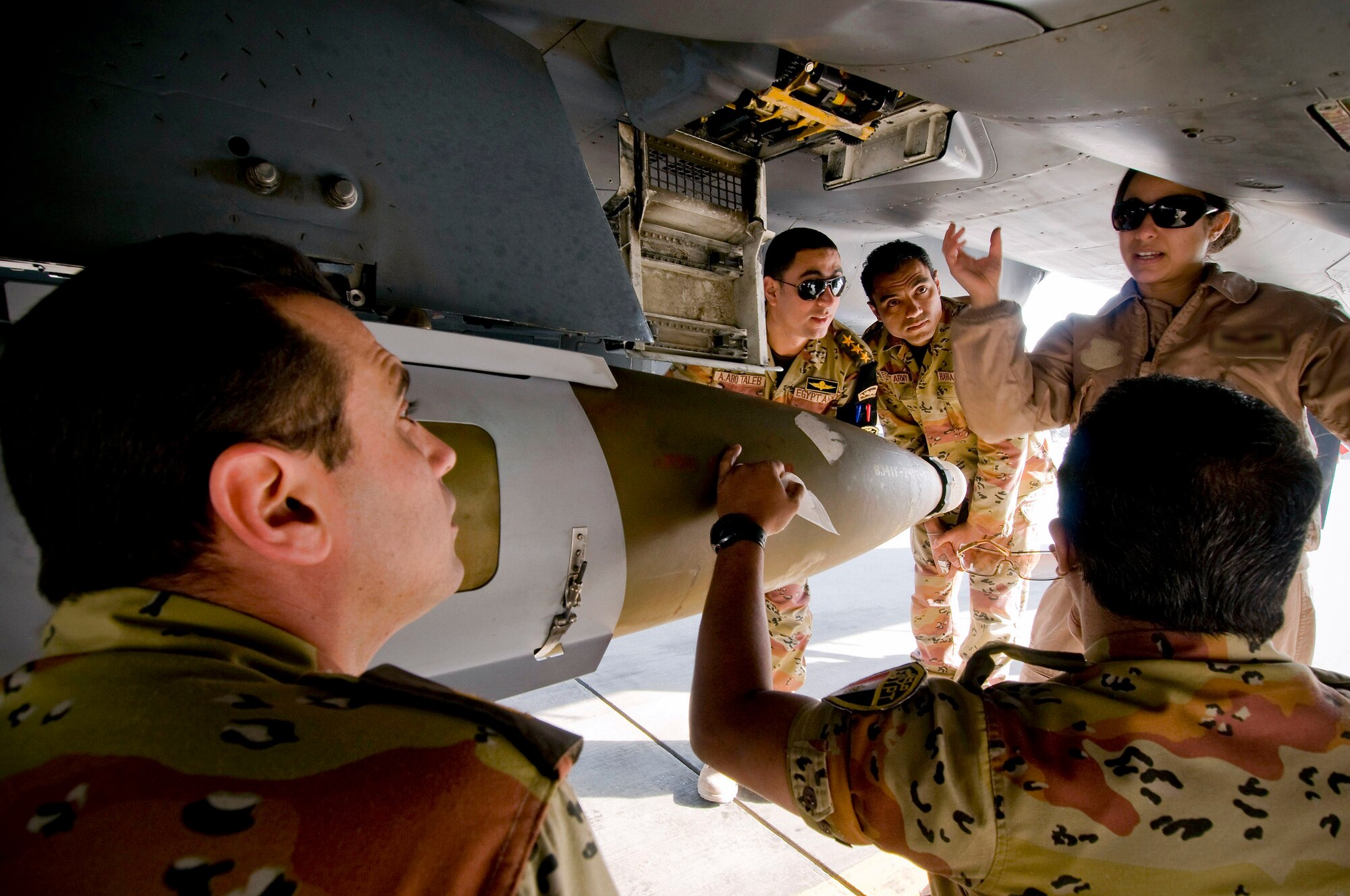 An F-15E Strike Eagle weapons systems officer explains the role of the F-15E's machine gun to a group of Egyptian medical personnel at Bagram Airfield, Afghanistan, Nov. 29. Being from Egyptian descent, the WSO was able to give most the tour in Arabic, avoiding any potential language barriers. (U.S. Air Force photo/Staff Sgt. Samuel Morse)