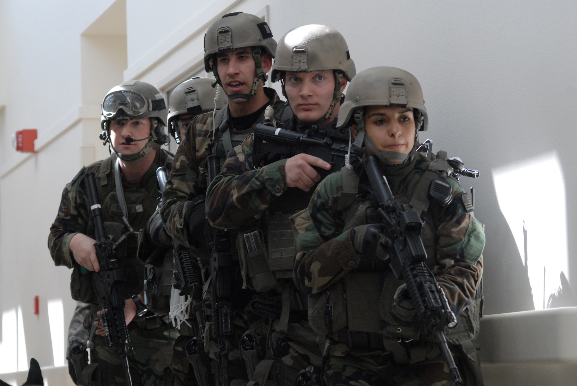 Members of the 341st Security Forces Group Tactical Response Force, from front to back, Airman 1st Class Liseth Rodriguez, Senior Airmen Jeremy Thatcher and Steve Kooyman, Staff Sgt. David Barger and Tech. Sgt. Clayton Thomas, work together to locate a shooter during an exercise scenario at the Malmstrom Clinic March 28. (U.S.. Air Force photo/John Turner)