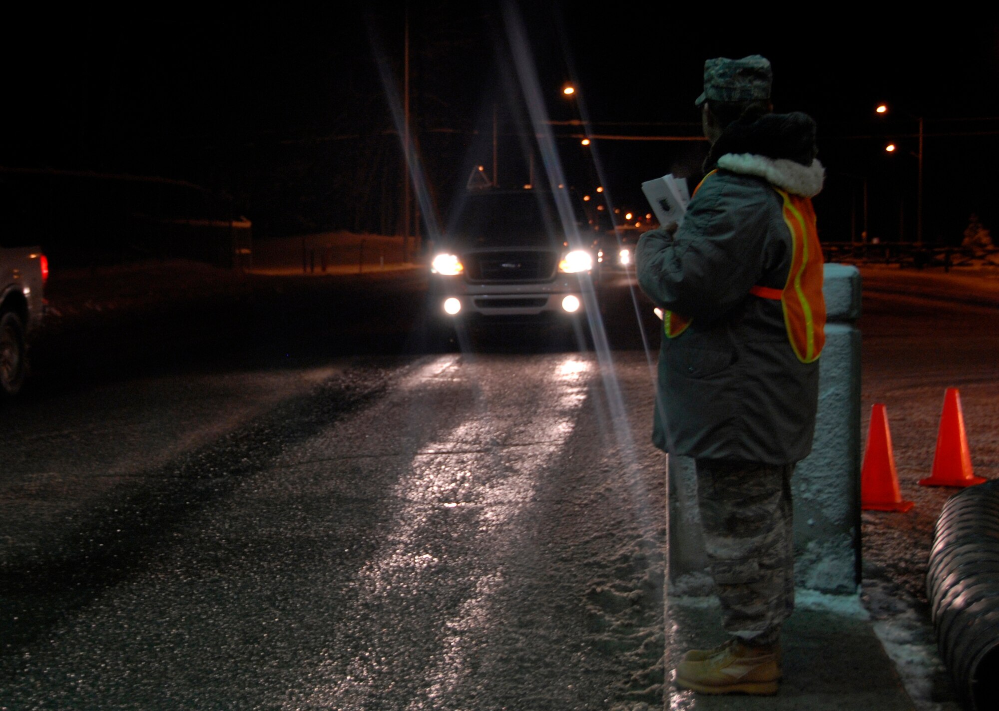 ELMENDORF AIR FORCE BASE, Alaska -- Tech. Sgt. Tina Anaya, 3rd Medical Support Squadron, stops vehicles as they leave base Dec. 6 handing them "Wingman Cards" reminding people to have a plan before they drink. Sergeant Anaya is a volunteer for the Alcohol Task Force which was initiated to help eliminate DUI's on Elmendorf. The Alcohol Task Force will be at the outbound gates from 10 p.m.-midnight Friday and Saturday nights. (U.S. Air Force photo/Airman 1st Class Cynthia Spalding)