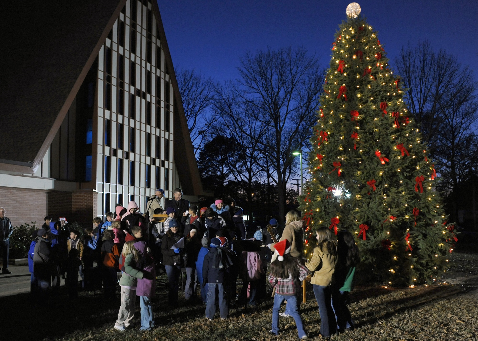 LANGLEY AIR FORCE BASE, Va. -- Children gather around Brig. Gen. Mark Barrett, 1st Fighter Wing commander as he lights the Christmas tree at the Bethel Manor Chapel Dec. 7. The lighting of the Christmas tree is an annual event that kicks off the Christmas season. (U.S. Air Force photo/Airman 1st Class Jonathan Koob)