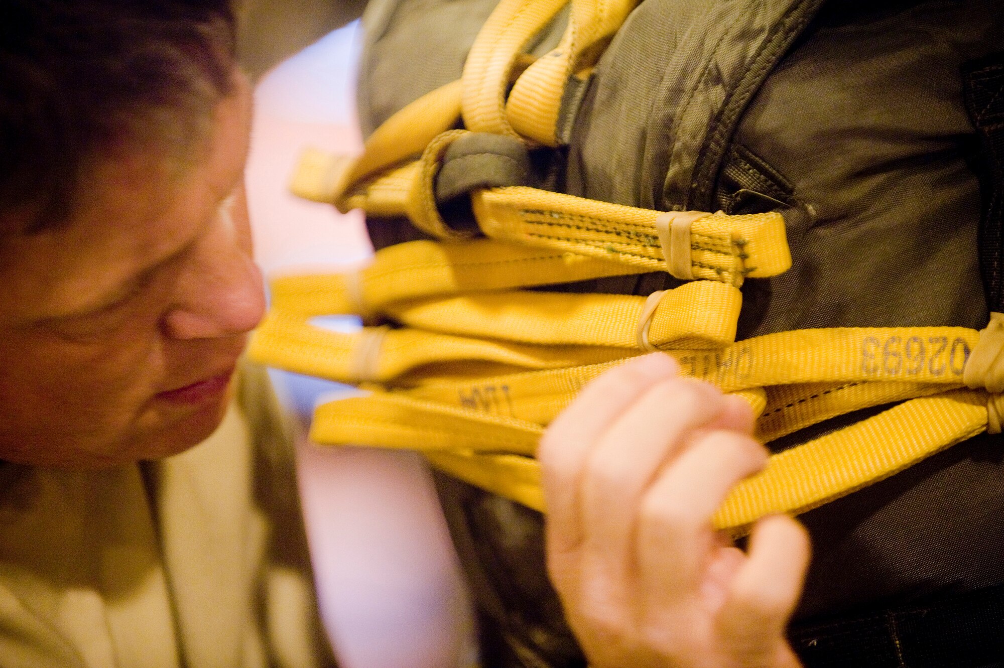 ELMENDORF AIR FORCE BASE, Alaska -- Army Sgt. 1st Class Billy Slagle, 725th Brigade Support Battalion, inspects a static line on a parachute at Joint Mobility Complex Dec. 8. The 4th Brigade Combat Team, 25th Infantry Division partnered with the 517th Airlift Squadron is using this week to practice jumps prior to the 4-25th's deployment. Roughly 1,300 4-25 Soldiers will be jumping out of C-17 Globemaster IIIs during the week. (U.S. Air Force photo/Senior Airman Jonathan Steffen)
