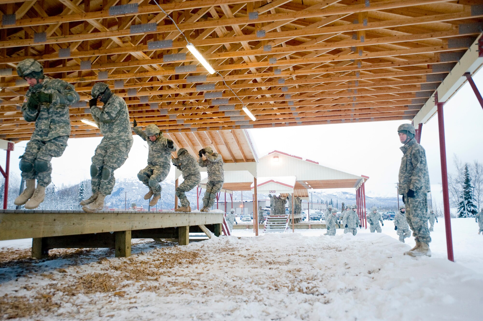 FORT RICHARDSON, Alaska -- Army Sgt. 1st Class John Beegle, 725th Brigade Support Battalion jump masters, tells soldiers to practice their parachute landing at Airborne Sustainment Training Area Dec.8. The 4th Brigade Combat Team, 25th Infantry Division partnered with the 517th Airlift Squadron is using this week practice jumps prior to the deployment. Roughly 1,300 4-25 Soldiers will be jumping out of C-17 Globemaster IIIs during the week. (U.S. Air Force photo/Senior Airman Jonathan Steffen)