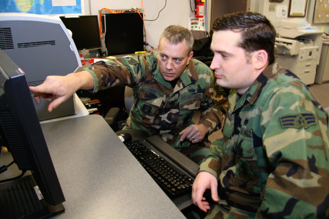 GRISSOM AIR RESERVE BASE, Ind. -- Senior Master Sgt. Greg Minnich works with Senior Airman Caleb Webster in "the vault" during a unit training assembly here. Both Sergeant Minnich and Airman Webster are 434th Operations Support Squadron intelligence specialists. Sergeant Minnich was recently named 434th Air Refueling Wing Senior Noncommissioned Officer of the Year. The Sergeant said he attributes winning the award to the skills, knowledge and abilities he has learned over the course of several deployments. (U.S. Air Force photo/Staff Sgt. Mark R. W. Orders-Woempner) 