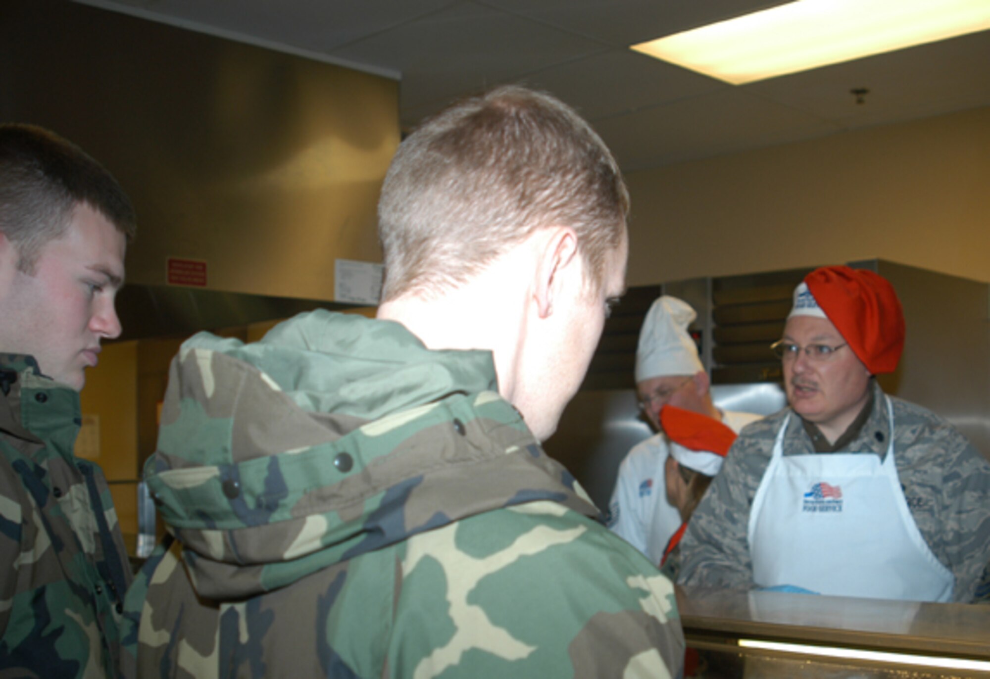 GRISSOM AIR RESERVE BASE, Ind., -- Lt. Col. Steve Whicker (right), 434th Maintenance Officer, works one of the serving lines during the recent holiday meal at Grissom.  Commanders and Senior Noncommissioned Officers participated in the tradition of helping to serve the holiday meal to unit personnel.  (U.S. Air Force photo/Staff Sgt. Ben Mota)                                