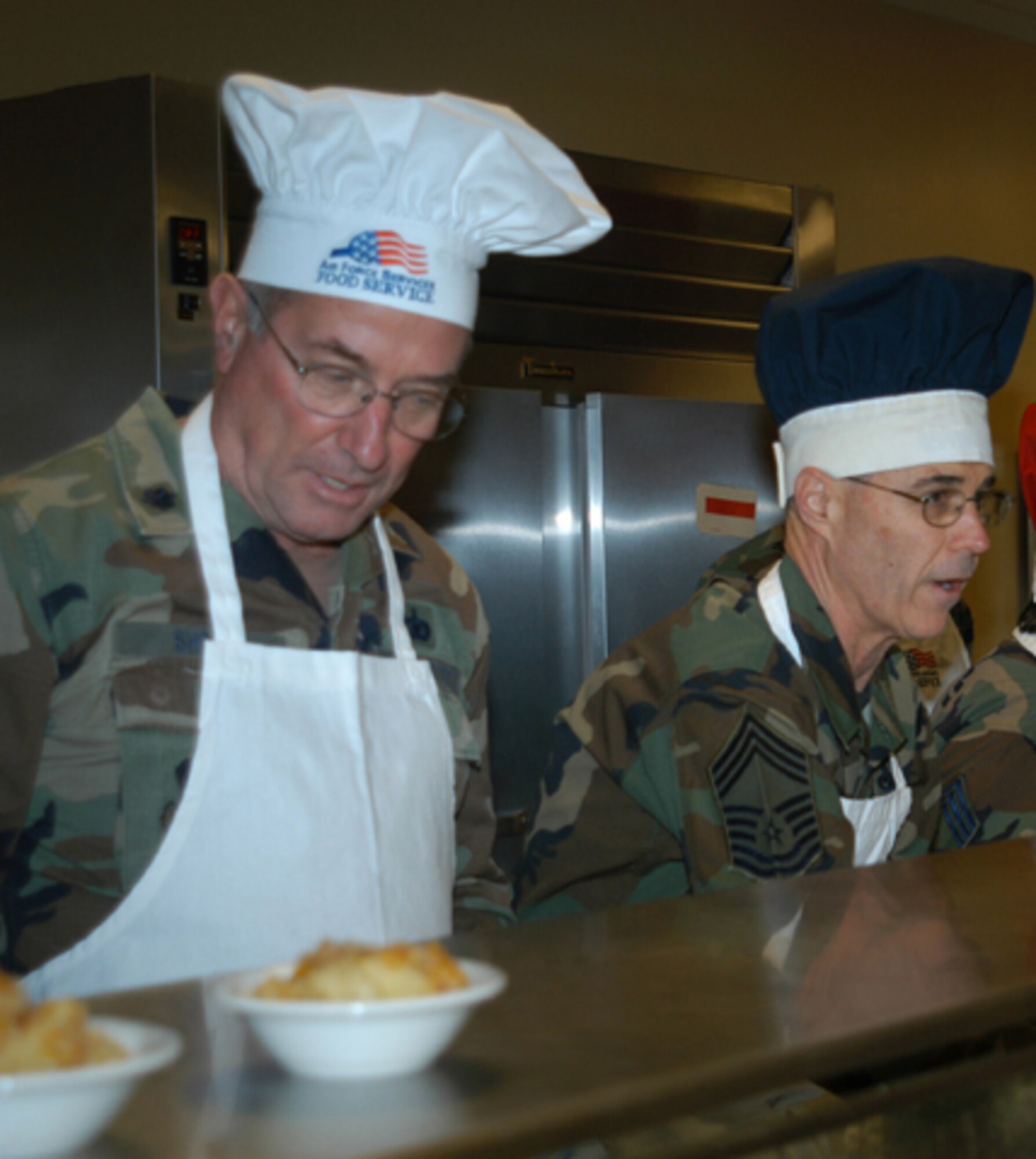 GRISSOM AIR RESERVE BASE, Ind., -- Lt. Col. Phil Shott (left), 434th Mission Support Group deputy commander, and Chief Master Sgt. David Sward, 434th Maintenance Squadron superintendent, were just two of a number of senior leaders who helped serve food during the annual Christmas meal at Grissom ARB.   It is a long-standing tradition at the base for senior leaders to assist with the holiday meal.  (U.S. Air Force photo/Staff Sergeant Ben Mota)                             