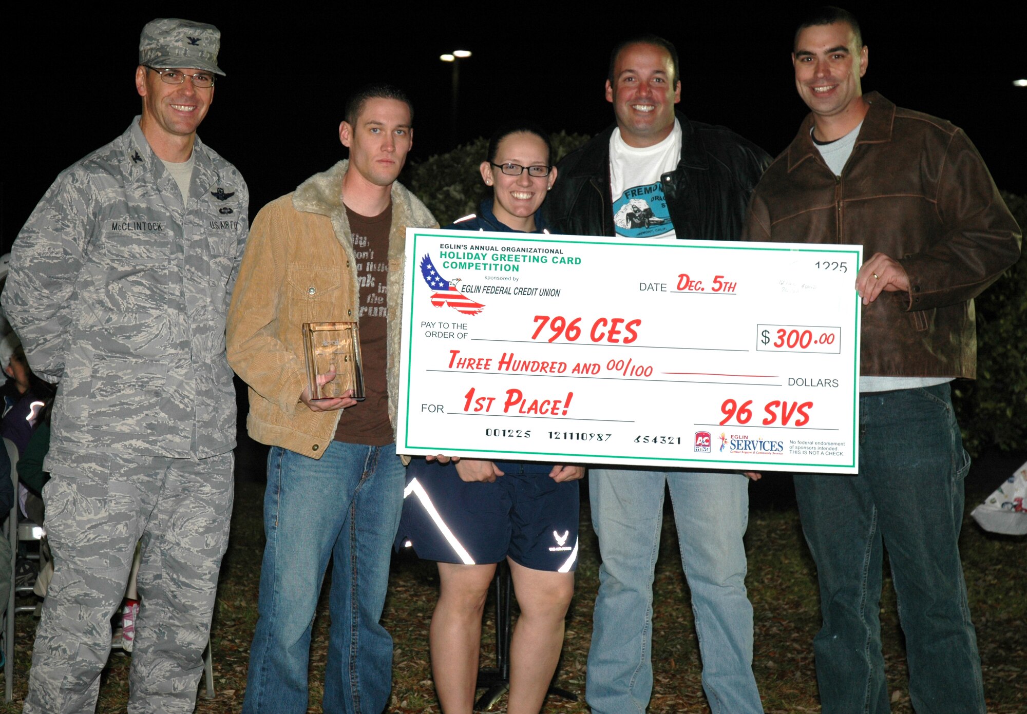 EGLIN AIR FORCE BASE, Fla. -- 796th Civil Engineer Squadron received a check for $300 Dec. 5, during the Holiday Tree Lighting Ceremony at the West Gate Chapel, for their competitive spirit in the Holiday Greeting Card Competition. Team Eglin celebrated together in anticipation of the upcoming holiday season with christmas carols, cookies, cocoa, and of course the opportunity for to sit on Santa's lap and tell him how good you've been. (U.S. Air Force photo/ Airman 1st Class Anthony Jennings)