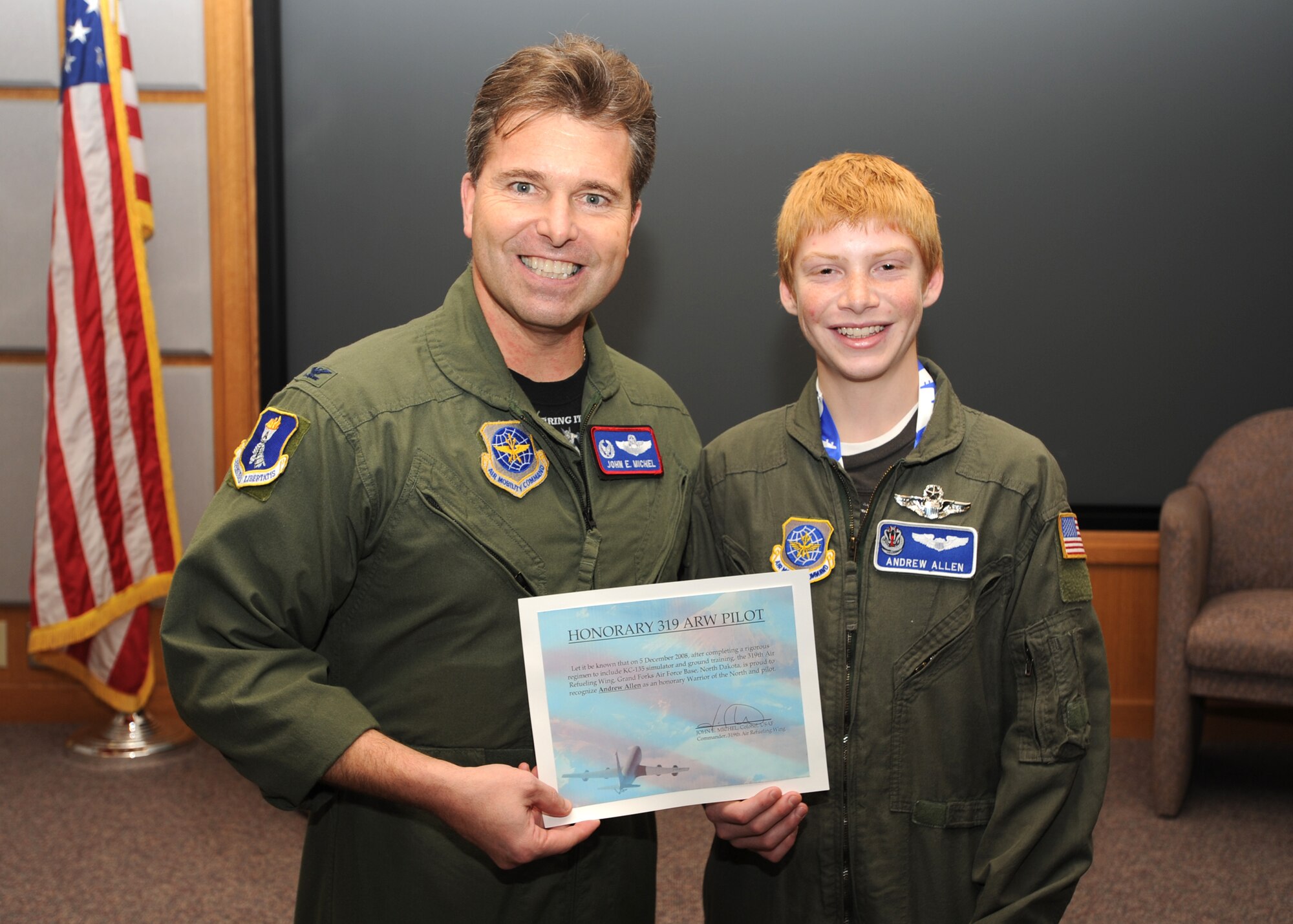 Col. John Michel, 319th Air Refueling Wing commader, presents Andrew Allen with a set of honorary pilot wings and a certificate at a presentation ceremony Dec. 5. (U.S. Air Force photo by Staff Sgt. Suellyn Nuckolls)