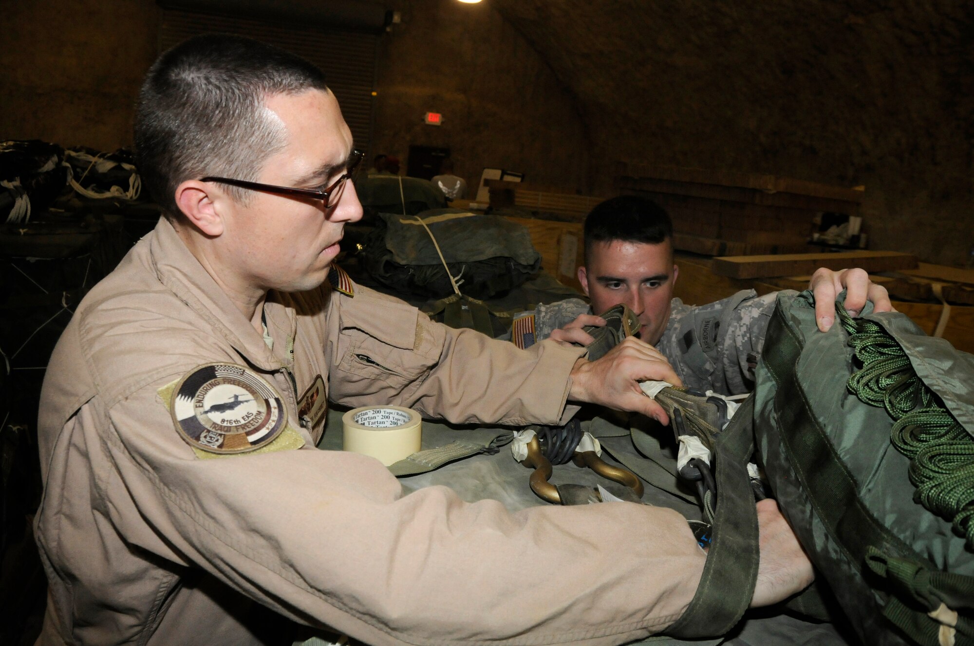 Tech. Sgt. Keith Hackney, C-17 joint airdrop inspector assigned to the 816th Expeditionary Airlift Squadron, inspects the clevis while Sgt. Joshua Sheptock, parachute rigger assigned to the 824th Riggers, ensures the webbing is attached correctly Dec. 6, 2008, at an undisclosed air base in Southwest Asia. This joint inspection was performed to ensure the container delivery system was rigged correctly so it can be used to drop supplies in the area of responsibility. Sergeant Hackney, a native of Frederick, Md., is deployed from Charleston Air Force Base, S.C., and Sergeant Sheptock, a native of Fayetteville, N.C., is deployed from Fort Bragg, N.C. Both are deployed in support of Operations Iraqi and Enduring Freedom and Joint Task Force-Horn of Africa. (U.S. Air Force photo by Staff Sgt. Darnell T. Cannady/Released)