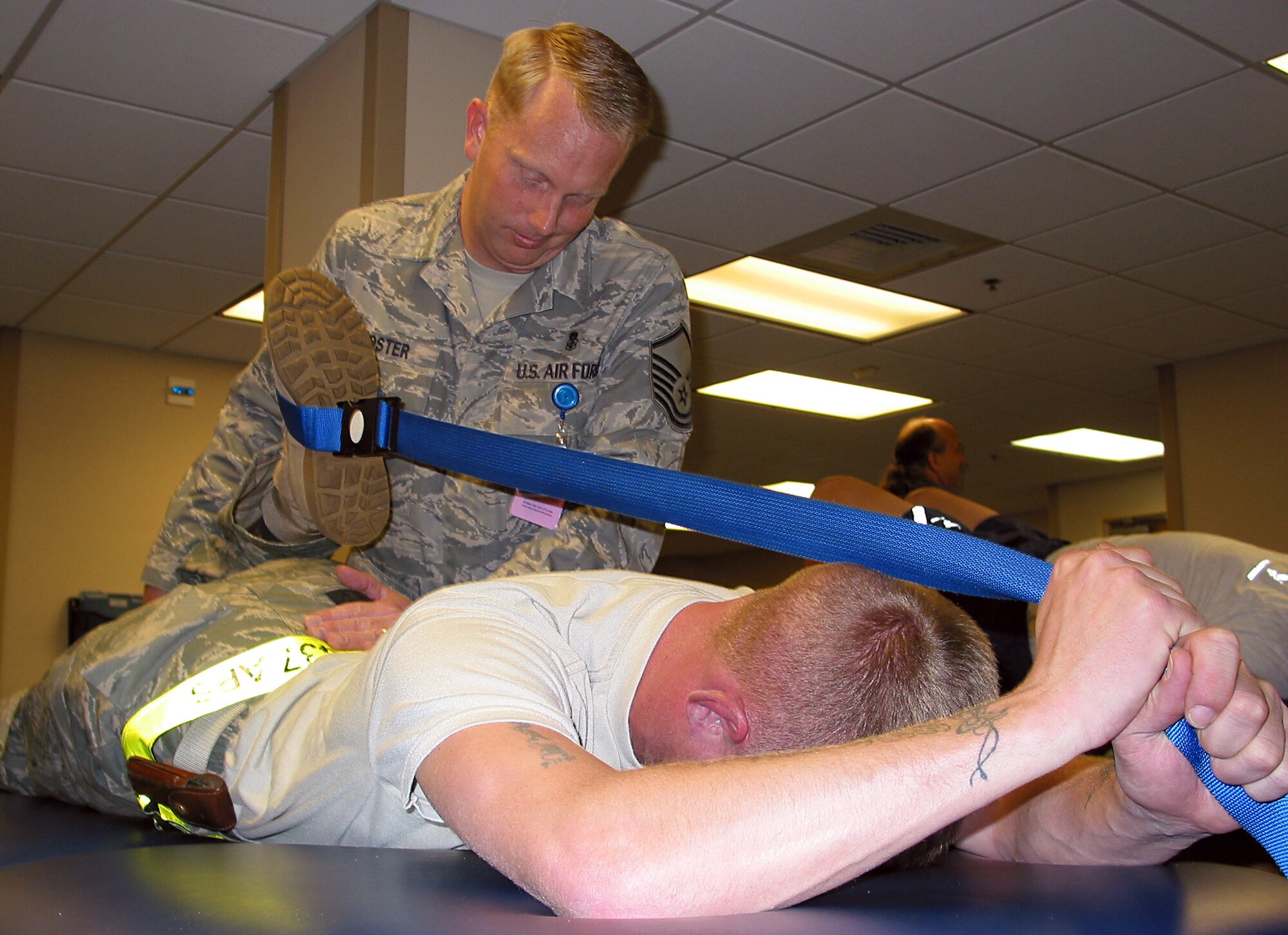 Master Sgt. Jason Foster helps Staff Sgt. Charles Register stretch his hip flexor muscle at the 437th Medical Operations Squadron Physical Therapy Department on base Dec. 3.  The clinic rehabilitates more than 200 Airmen per week for their return to duty to be fit to fight. Sergeant Foster is the NCO in charge of the Physical Therapy Department and Sergeant Register is with the 437th Aerial Port Squadron. (U.S. Air Force by/Staff Sgt. Jennifer Arredondo)