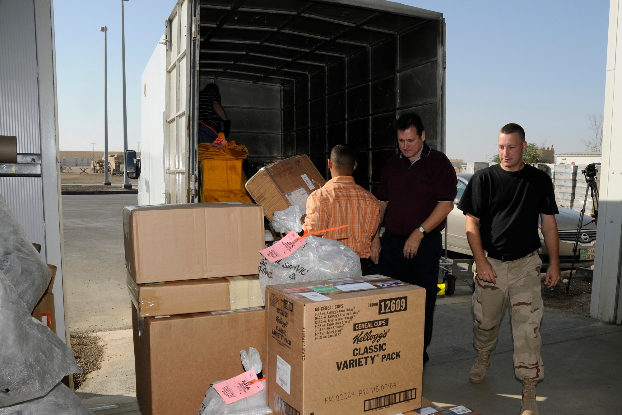 SOUTHWEST ASIA -- From left to right, Mike Ruzza, Oneris Barett, Scott Kirsch and Senior Airman Christopher Teixeira load a mail truck with outgoing mail here Dec. 8. Airman Teixeira is with the 380th Expeditionary Civil Engineer Fire and Emergency Services. The civilians work for Alutiiq International Solutions LCC. Alutiiq International Solutions is contracted to provide personnel and services for the 380th Air Expeditionary Wing's Post Office. They are busy trying to keep the mail coming and going during the busy holiday season. Mr. Ruzza is a native of Tampa Bay, Fla. Mr. Barett is from Bronx, N.Y. Mr. Kirsch hails from Toledo, Ohio, and Airman Teixeira is deployed from the 28th CES, Ellsworth Air Force Base, S.D. and his hometown is Battle Creek, Mich. (U.S. Air Force photo/Tech. Sgt. Christopher A. Campbell)(released)
