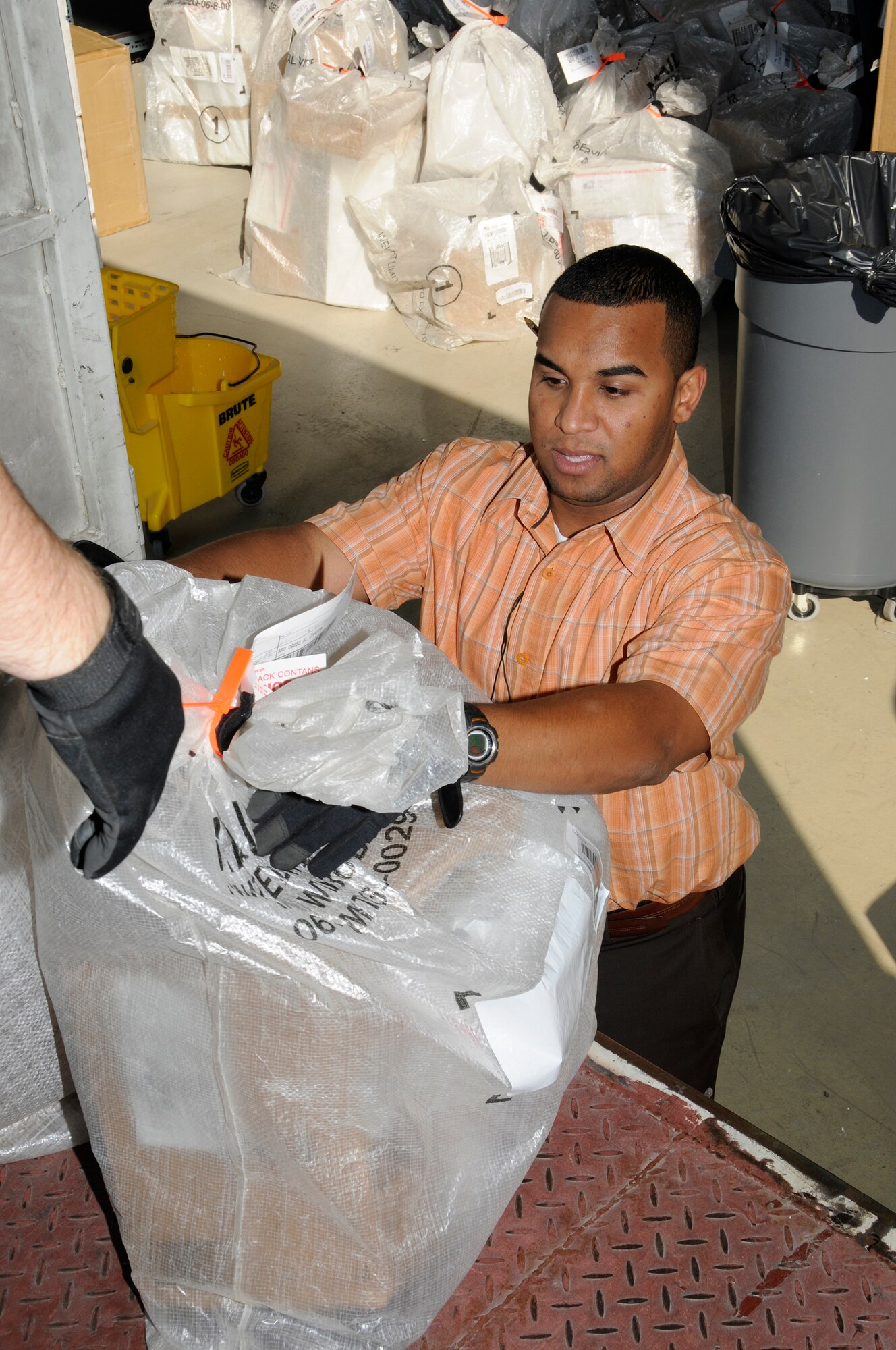 SOUTHWEST ASIA -- Mr. Oneris Barett inspects packages delivered to the 380th Air Expeditionary Wing for damage here Dec. 8. Mr. Oneris works for Alutiiq International Solutions LCC. This company is contracted to provide personnel and services for the 380th Air Expeditionary Wing Post Office. He is busy trying to keep the mail coming and going during the busy holiday seasons. Mr. Oneris is from Bronx, N.Y. (U.S. Air Force photo/Tech. Sgt. Christopher A. Campbell)(released)