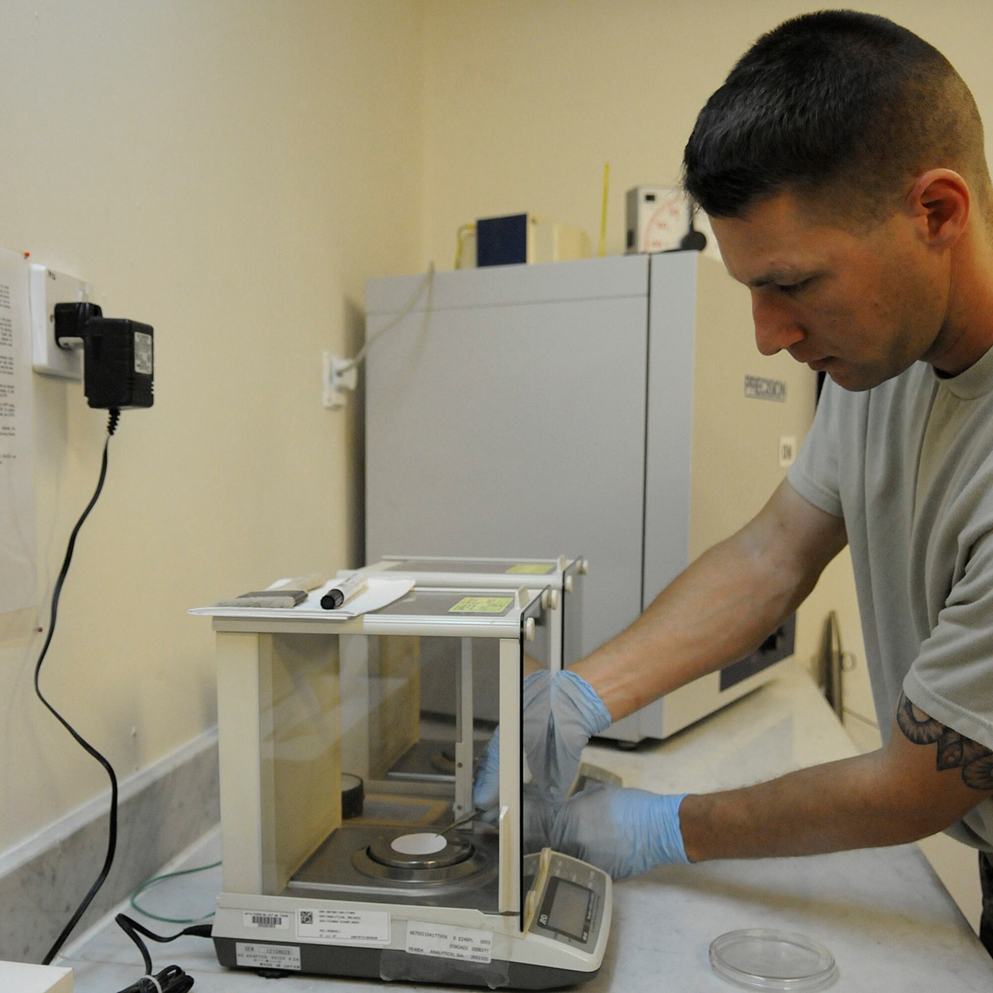 Staff Sgt. Ronald Gasper, a fuels lab technician assigned to the 379th Expeditionary Logistics Readiness Squadron, weighs a filter membrane prior to performing a bottle method test, Dec. 8, at an undisclosed air base in Southwest Asia. The filter membrane is weighed before and after a bottle method test, the differences in weight will show the amount of impurities in the fuel.  The weekly bottle method test is used to test the fuel truck's filter separator and how well it is screening impurities from the fuel.  Sergeant Gasper, a native of Omaha, Neb., is deployed from Scott Air Force Base, Ill., in support of Operations Iraqi and Enduring Freedom and Joint Task Force-Horn of Africa.  (U.S. Air Force photo by Tech. Sgt. Michael Boquette/Released)