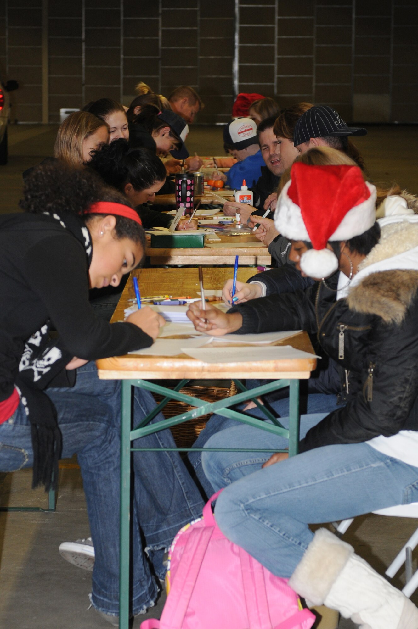 Volunteers from the Kaiserslautern Middle School Keystone Club and the community, write letters to service members deployed during the holidays for Project Rudolph, Rhine Ordnance Barracks, Germany, Dec 6, 2008. Over 1,100 bags were assembled on Saturday to be sent downrange for the holidays. (U.S. Air Force photo by Senior Airman Kelly LeGuillon)