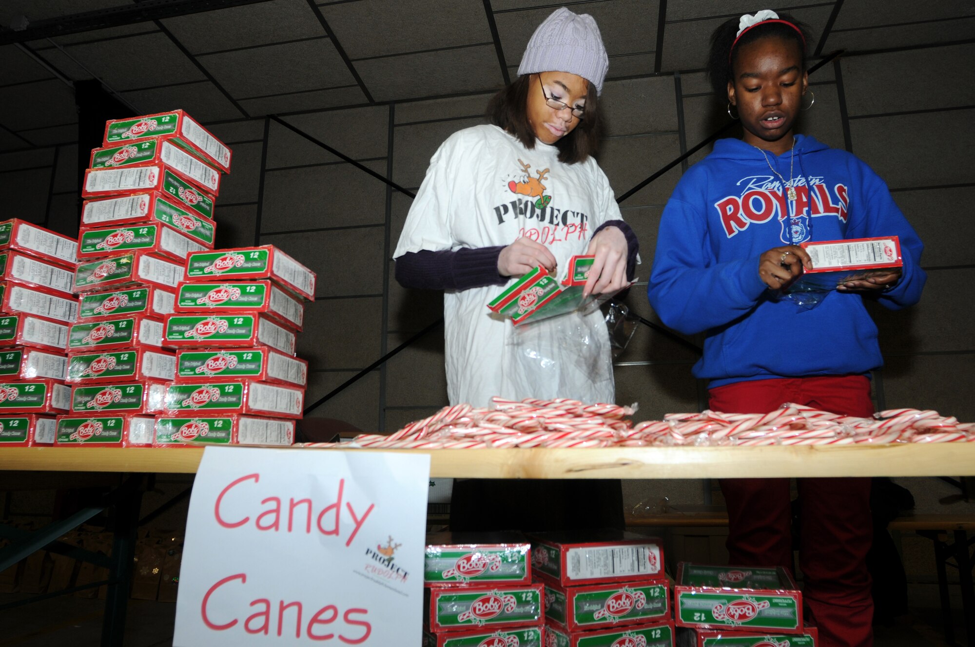 Kelsey Dangerfield and Alyna Avance, volunteers from Ramstein High School, fill gift bags with candy canes on an assembly line for Project Rudolph, Rhine Ordnance Barracks, Germany, Dec 6, 2008. Over 1,100 bags were assembled on Saturday to be sent downrange for the holidays. (U.S. Air Force photo by Senior Airman Kelly LeGuillon)
