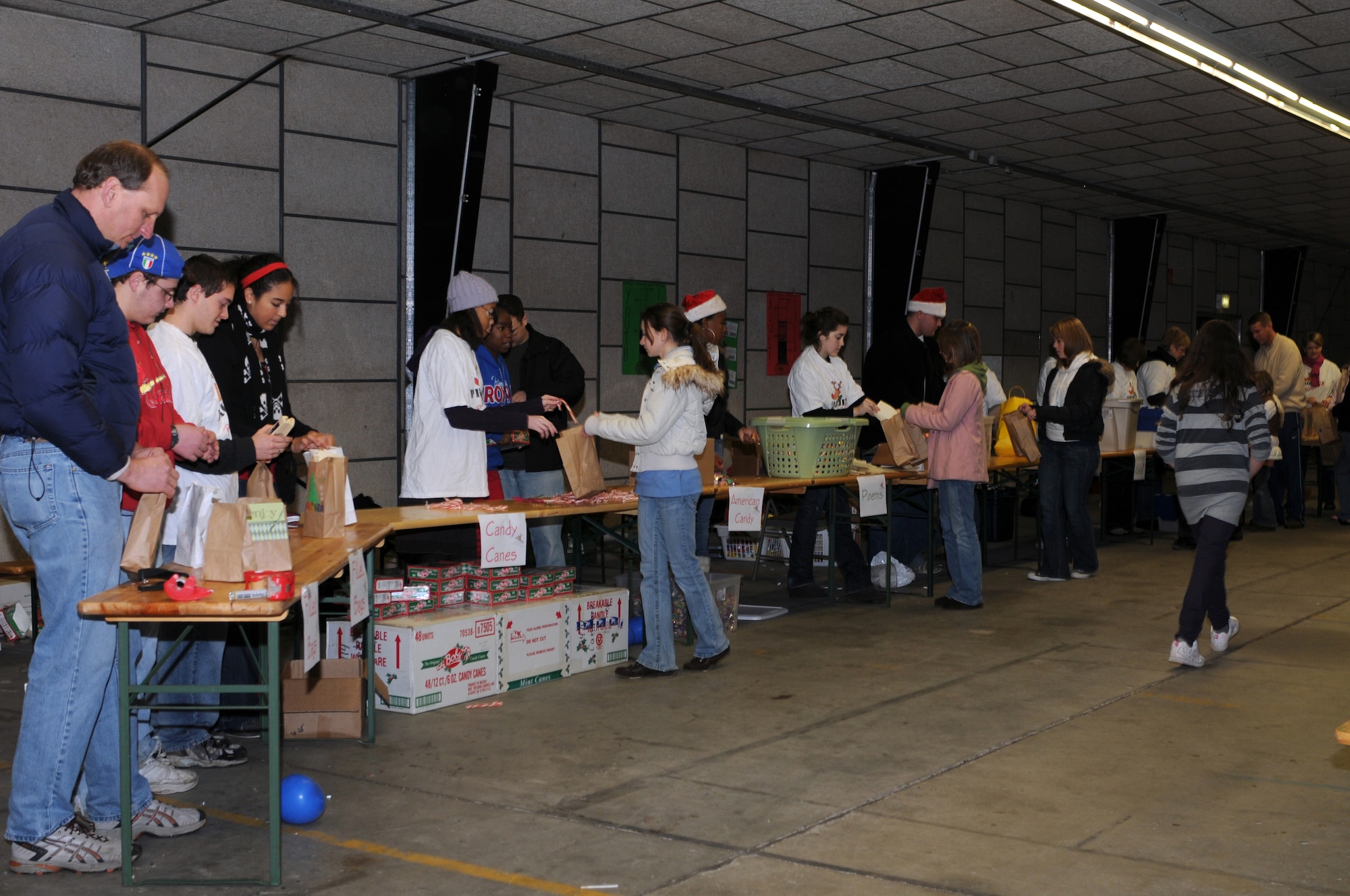 Volunteers from the Kaiserslautern Middle School Keystone Club fill gift bags on an assembly line for Project Rudolph, Rhine Ordnance Barracks, Germany, Dec 6, 2008. Over 1,100 bags were assembled on Saturday to be sent downrange for the holidays. (U.S. Air Force photo by Senior Airman Kelly LeGuillon)