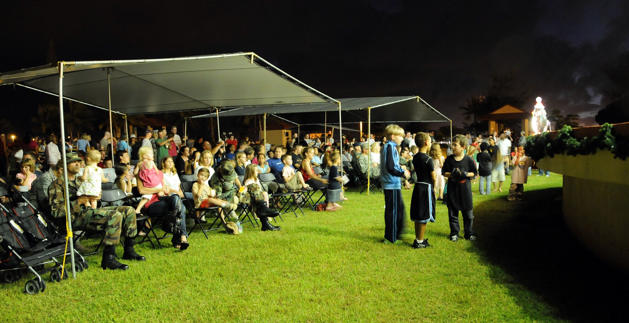 ANDERSEN AIR FORCE BASE, Guam – On-lookers watch an on stage musical performance before the lighting of the Christmas tree here Dec. 4. Anticipation grew as children waited for the man of the hour, Santa Claus to appear.  (U.S. Air Force photo by Airman 1st Class Courtney Witt)