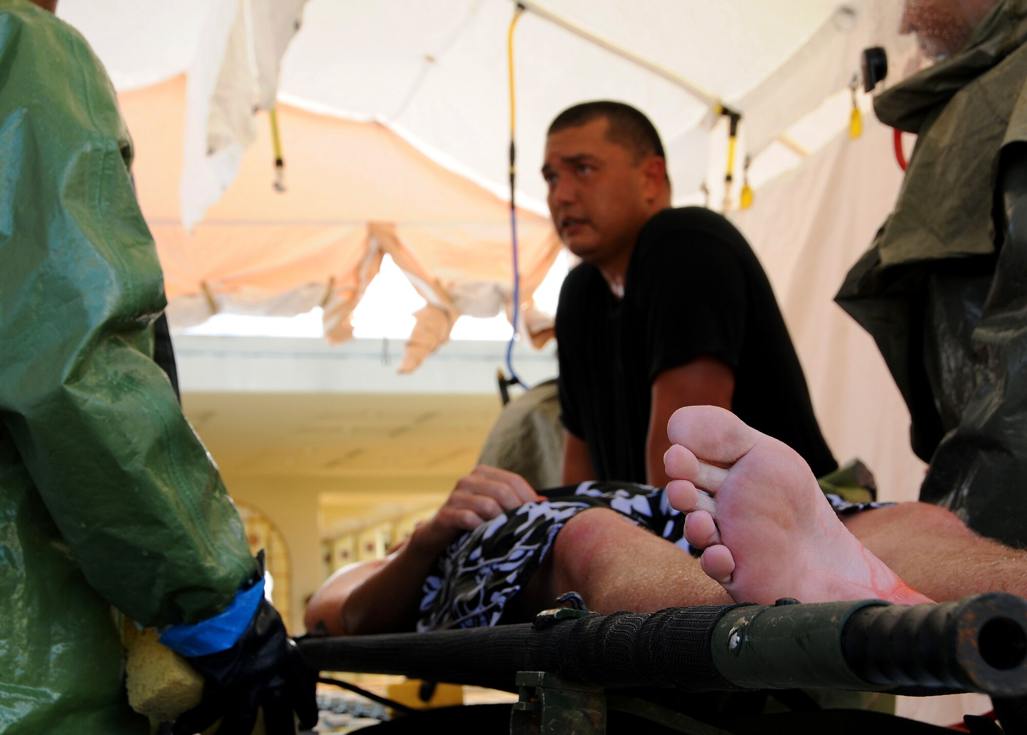 ANDERSEN AIR FORCE BASE, Guam - Tech. Sgt. Marlon Pugh, 36th Medical Group non-commissioned officer in charge of laboratory, conducts training with members of the medical group during the Emergency Management Exercise here Dec. 3. Sergeant Pugh was one of many who had gone through In-Place Patient Decontamination Capability Shelter training two months earlier. The shelter is a combination unit with two ambulatory lanes and one litter lane to handle large decontamination missions. (U.S. Air Force photo by Airman 1st Class Courtney Witt)