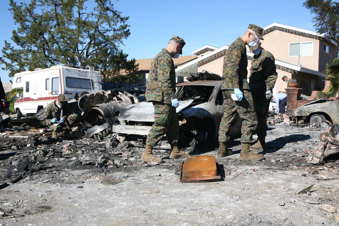 Marine Corps Air Station Miramar Marines help exam and remove debris from a crash site on Dec. 9 in San Diego after an F/A-18D “Hornet” crashed into a residential area that Monday.  The aircraft was returning to Marine Corps Air Station Miramar after conducting carrier landing qualifications aboard the USS Abraham Lincoln.