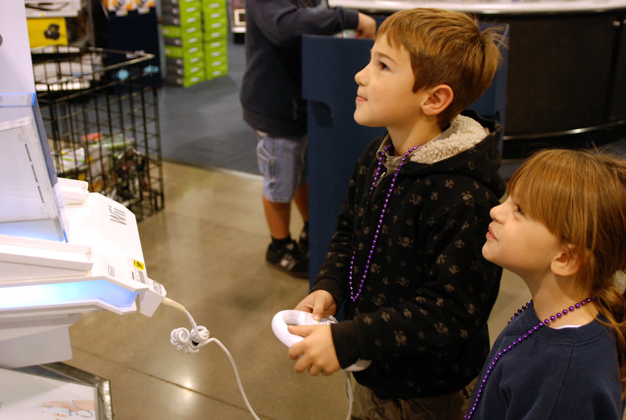 Jonathon, 7, and Emelyn, 6, Richardson play a video game at a Natomas electronics store Dec. 7, while their parents did a little holiday shopping. Parents Airman 1st Class Ira and Jennifer Richardson were there to receive a $200 shopping spree courtesy of Spencer Hawes, center for the Sacramento Kings.  (Photo by Staff Sgt. Sarah Gregory)