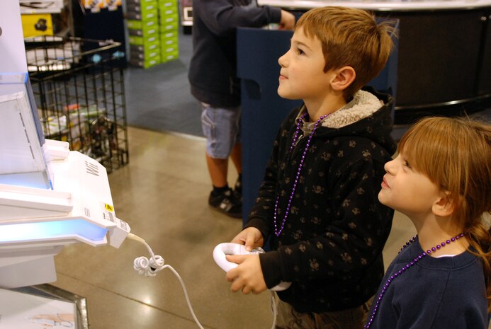 Jonathon, 7, and Emelyn, 6, Richardson play a video game at a Natomas electronics store Dec. 7, while their parents did a little holiday shopping. Parents Airman 1st Class Ira and Jennifer Richardson were there to receive a $200 shopping spree courtesy of Spencer Hawes, center for the Sacramento Kings.  (Photo by Staff Sgt. Sarah Gregory)