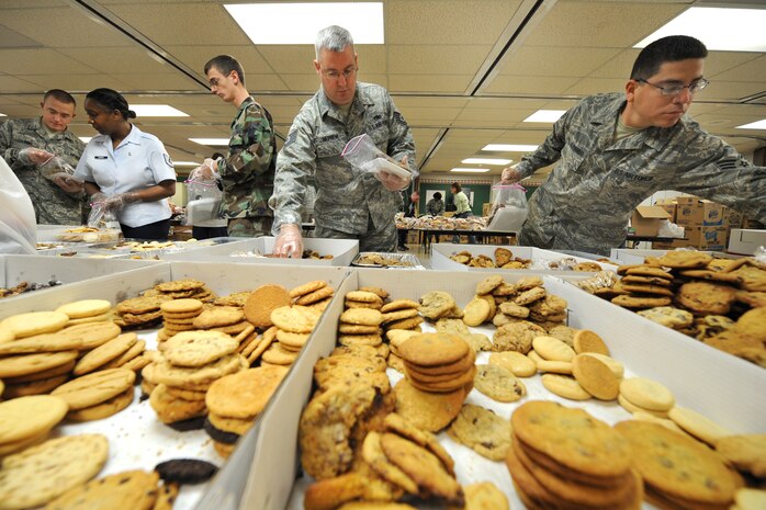 Members of the Nellis AFB community prepare bags of cookies for more than 1000 Airmen Dec. 8 at the Nellis chapel as part of the Nellis Cookie Drive. The Nellis community came together with more than 150 volunteers who donated more than 20,000 cookies. These treats were given to 880 Airmen in the Nellis area and 130 airmen deployed to various locations overseas(USAF Photo by Lawrence Crespo)