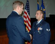 Senior Airman Thomas Adamo, Jr. (right), 919th Security Forces Squadron fire team member, is presented the Air Force Combat Action Medal by Col. Gary Nelson, 919th Mission Support Group commander, Saturday at Spectre Hall for his actions under fire while deployed on active duty in support of the Global War on Terrorism.  Serving as a 50-caliber gunner, Airman Adamo's defensive actions during an ambush on his convoy helped ensure his team suffered no casualties or loss of equipment. 