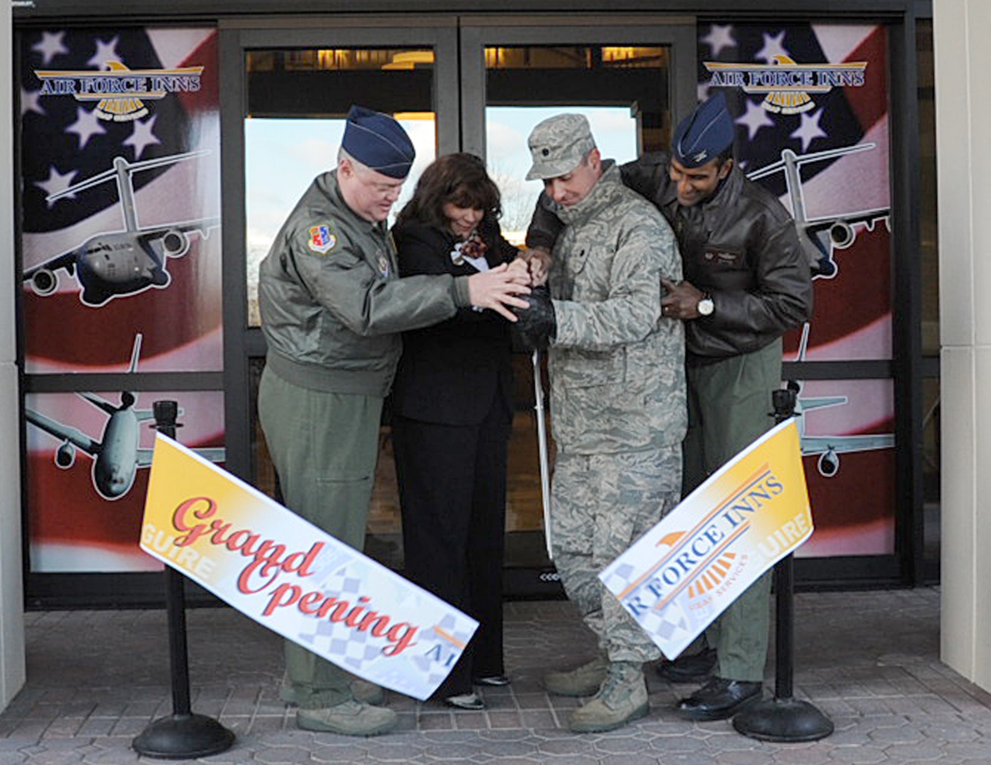 From left, Col. James Kerr, 514th Air Mobility Wing commander, Kathren Harting, McGuire All American Inn general manager, Lt. Col. John Clark, 305th Services Squadron commander, and Col. Balan Ayyar, 305th Air Mobility Wing commander, cut the ribbon to officially open the new base lodging facilities Dec. 5. (U.S. Air Force photo/Staff Sgt. Danielle Johnson)