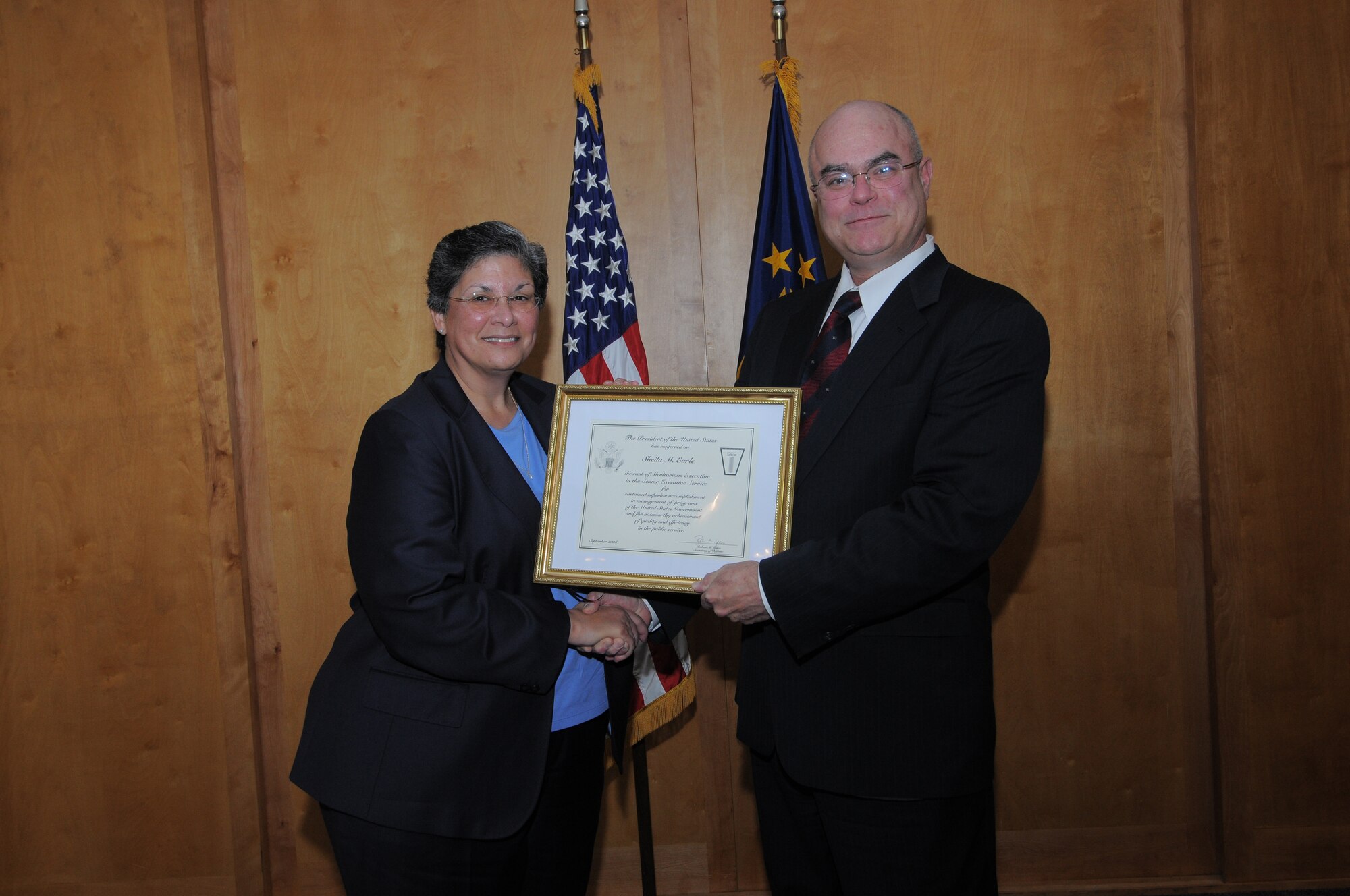 Bill Carr, Office of the Secretary of Defense Military Personnel Policy Office deputy undersecretary, presents the Presidential Rank Award to Sheila Earle, Air Force Personnel Center executive director, during a ceremony Dec. 9. Ms. Earle was conferred the rank of "Meritorious Executive in the Senior Executive Service" for her accomplishments in U.S. Government program management and for her quality and efficiency in service to the public. (U.S. Air Force photo by Melissa Peterson)
