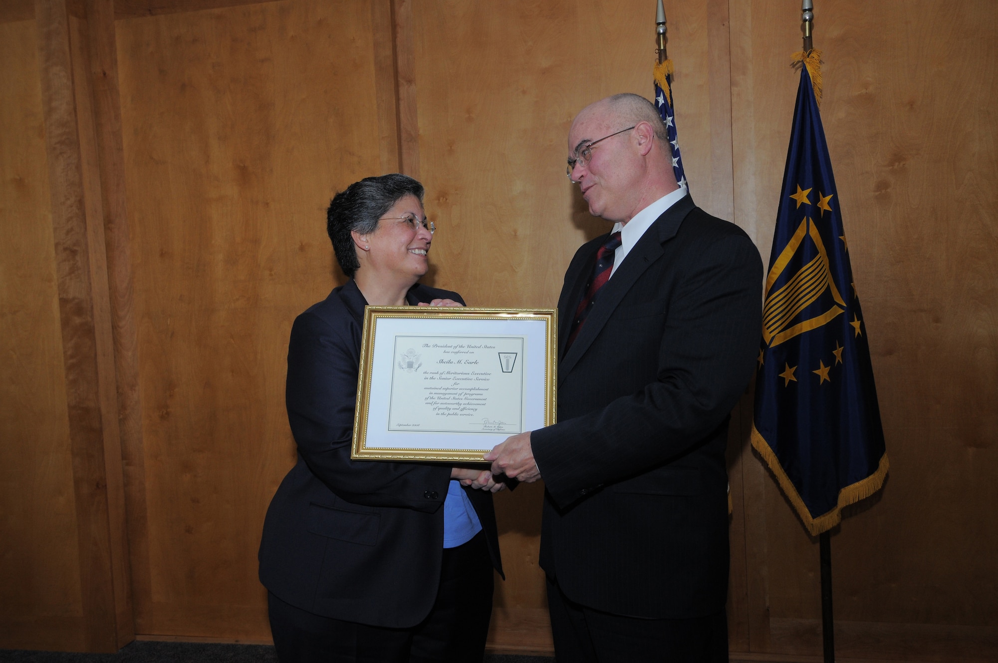 Bill Carr, deputy undersecretary military personnel policy, Office of the Secretary of Defense, presents a Presidential Rank Award to Sheila Earle, Air Force Personnel Center executive director, during a ceremony Dec. 9. Ms. Earle was conferred the rank of "Meritorious Executive in the Senior Executive Service" for her accomplishments in U.S. Government program management and for her quality and efficiency in service to the public. (U.S. Air Force photo by Melissa Peterson)
