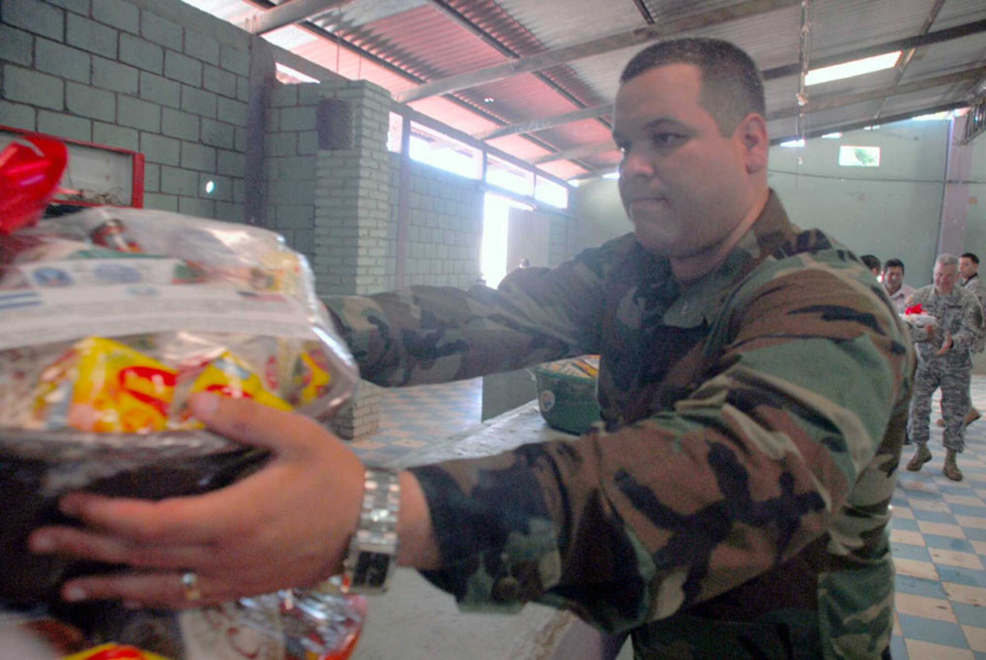 AJUTERIQUE, Honduras - Navy Petty Officer 3rd Class David Lazo, Joint Task Force-Bravo, assists moving food baskets to be given out to more than 100 families here Dec. 9. JTF-Bravo and U.S. Southern Command gave the baskets filled with essential food and supplies to families affected by widespread flooding recently. (U.S. Air Force photo by Staff Sgt. Joel Mease)
