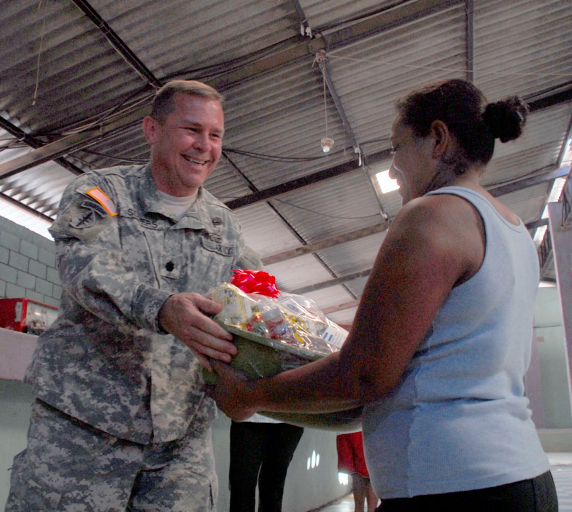 AJUTERIQUE, Honduras - Army Lt. Col. Richard Somers, Joint Task Force-Bravo Army Forces commander, gives a gift basket to a local Dec. 9. The baskets, full of essential food and supplies, were from JTF-Bravo and Southern Command to more than 100 local families who were recently affected by widespread flooding. (U.S. Air Force photo by Staff Sgt. Joel Mease) 