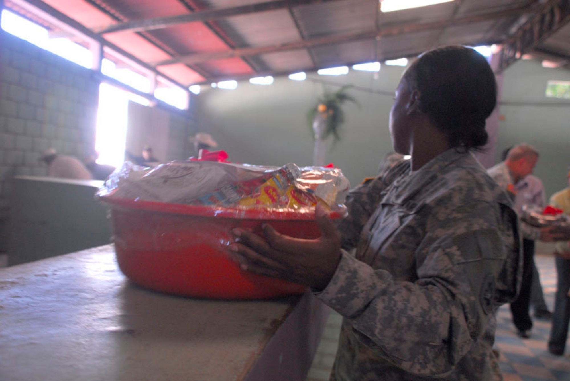 AJUTERIQUE, Honduras - Army Staff Sgt. Jenise Harris, Joint Task Force-Bravo, assists moving food baskets to be given out to more than 100 families here Dec. 9. JTF-Bravo and U.S. Southern Command gave the baskets filled with essential food and supplies to families affected by widespread flooding recently. (U.S. Air Force photo by Staff Sgt. Joel Mease)