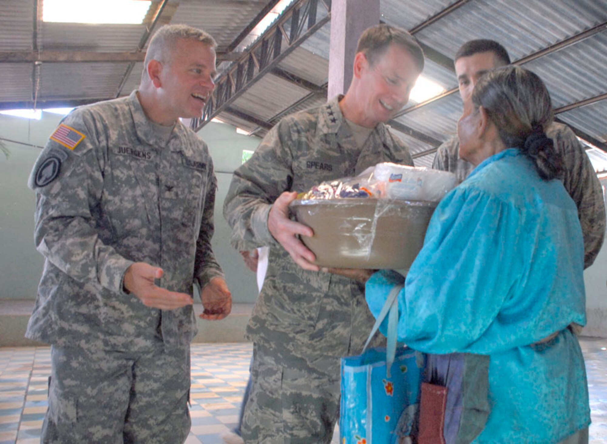 AJUTERIQUE, Honduras - Lt. Gen. Glenn Spears (center), U.S. Southern Command deputy commander, and Col. Richard Juergens (left), Joint Task Force-Bravo commander, give a local a gift basket from servicemembers at Soto Cano Air Base here Dec. 9. More than 100 families received a free basket containing food items and essential supplies as a way for JTF-Bravo to show their support for their community. (U.S. Air Force photo by Staff Sgt. Joel Mease)