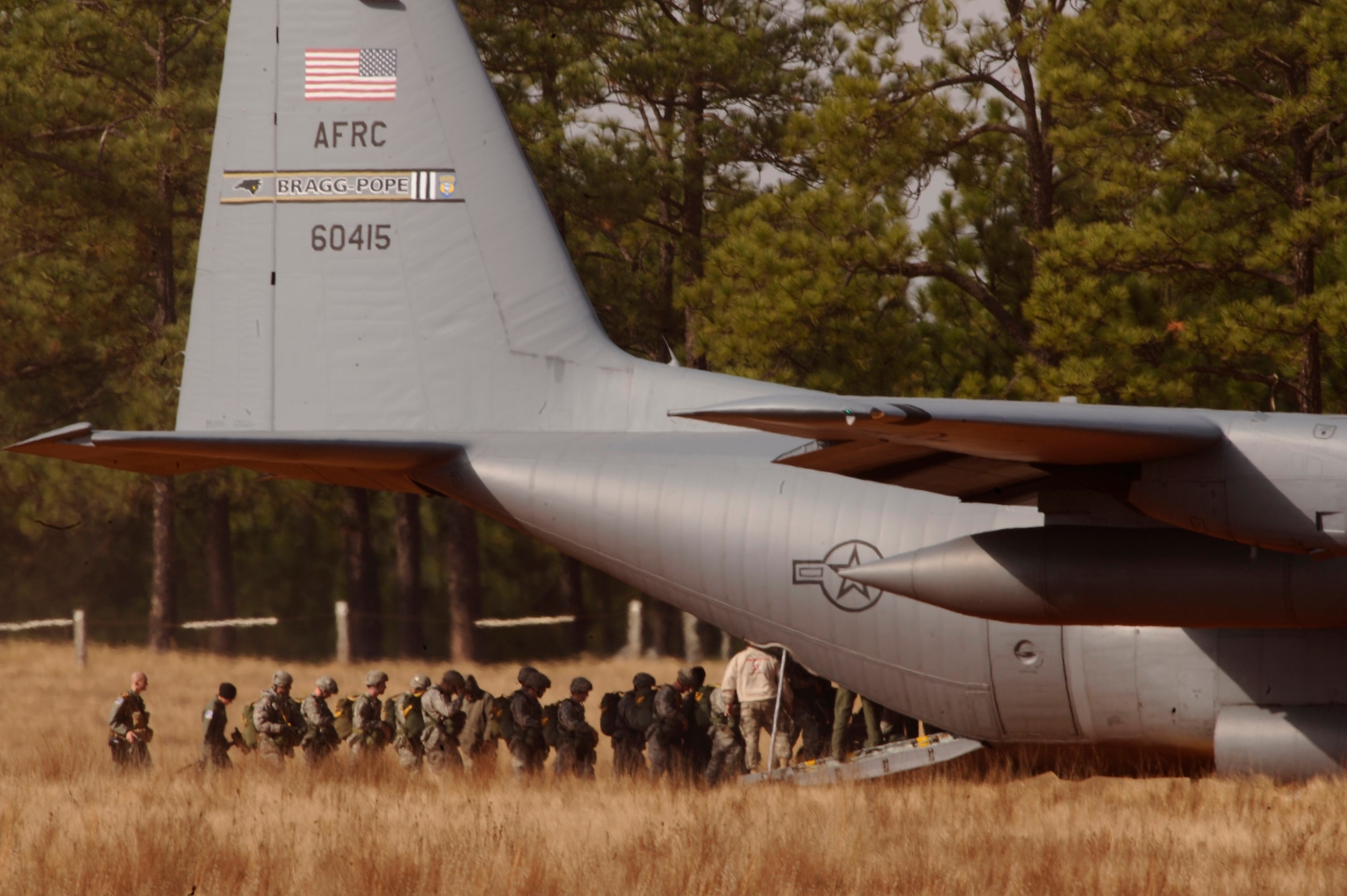 Army Soldiers from the 82nd Airborne Division load onto a C-130 Hercules before they parachute onto Drop Zone Sicily during Operation Toy Drop Dec. 6 at Fort Bragg, N.C. Operation Toy Drop is an annual Airborne jump at Fort Bragg in its 11th year hosted by the Army Civil Affairs and Psychological Operations Command (Airborne), and supported by Fort Bragg's XVIII Airborne Corps and the Air Force Reserve Command's 440th Airlift Wing that gives Soldiers and Airmen the opportunity to help local families in need over the holidays while boosting morale and incorporating valuable training. More than 3,000 Soldiers donated a toy for a lottery ticket and the chance to jump under a foreign jumpmaster, earning them their foreign jump wings. This year, German and Irish jumpmasters will be issuing the commands from C-130 Hercules aircraft during the operation. (U.S. Air Force photo/Senior Airman Ali E. Flisek) 